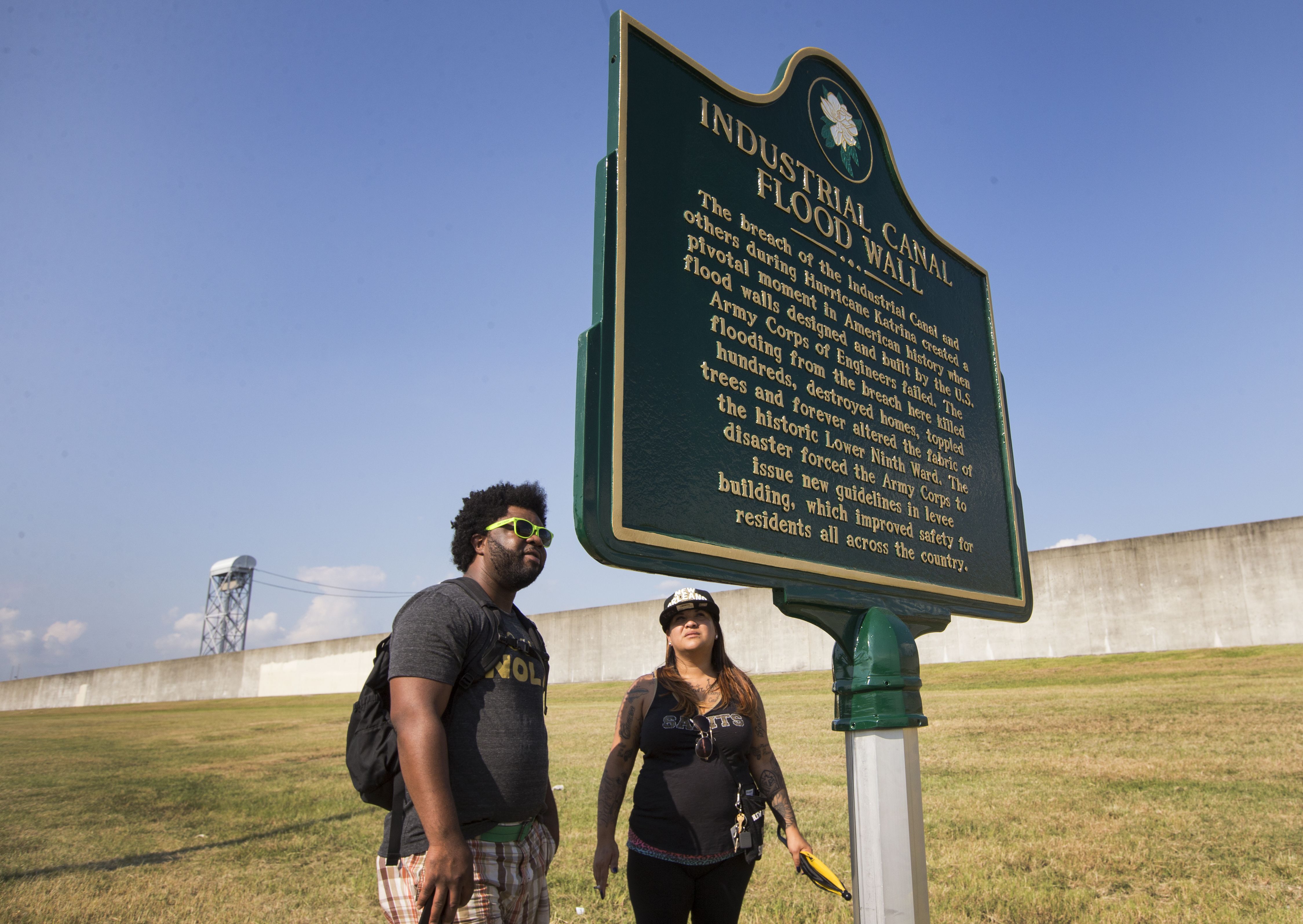 Photo shows two people looking at a historic marker in New Orleans.