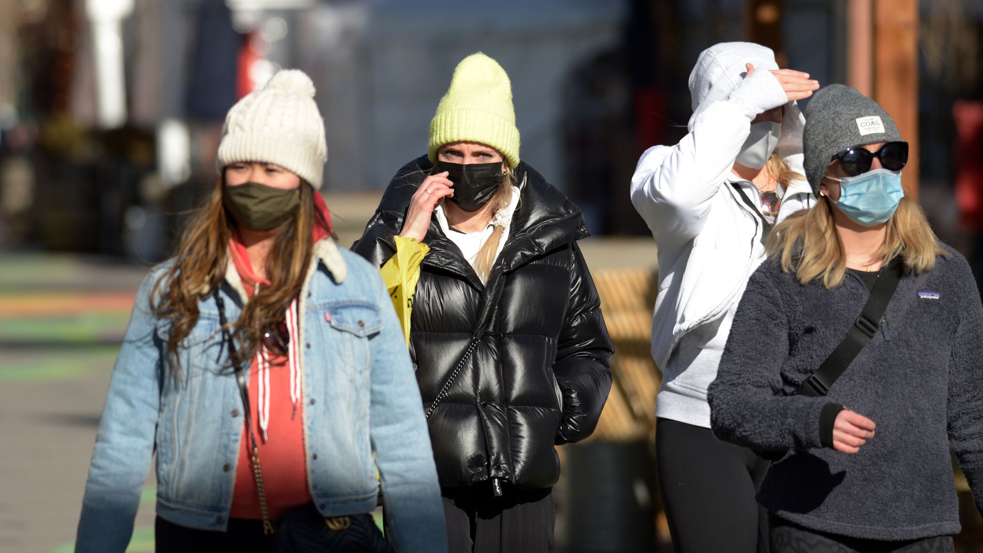 A photo of people wearing masks walking down Larimer Square in Denver. 