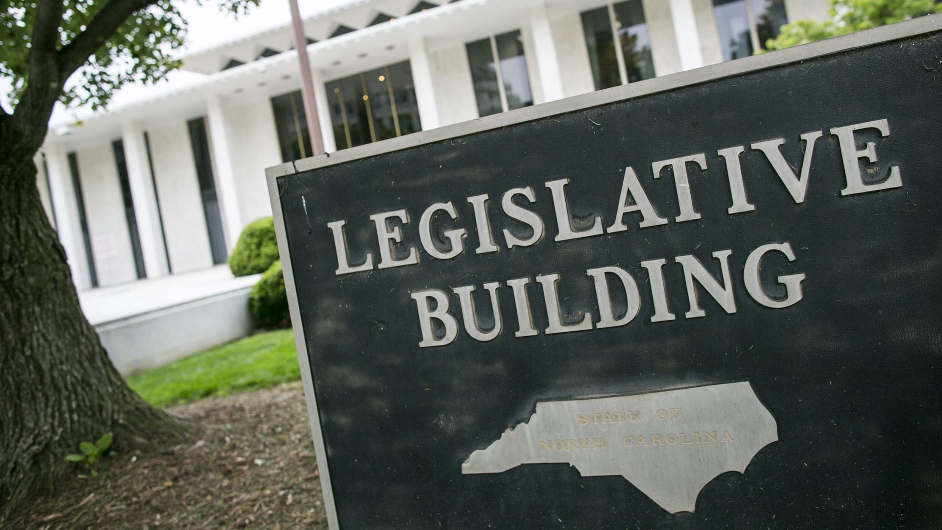 Photo of a sign that says "Legislative Building" and includes an image of the state of North Carolina