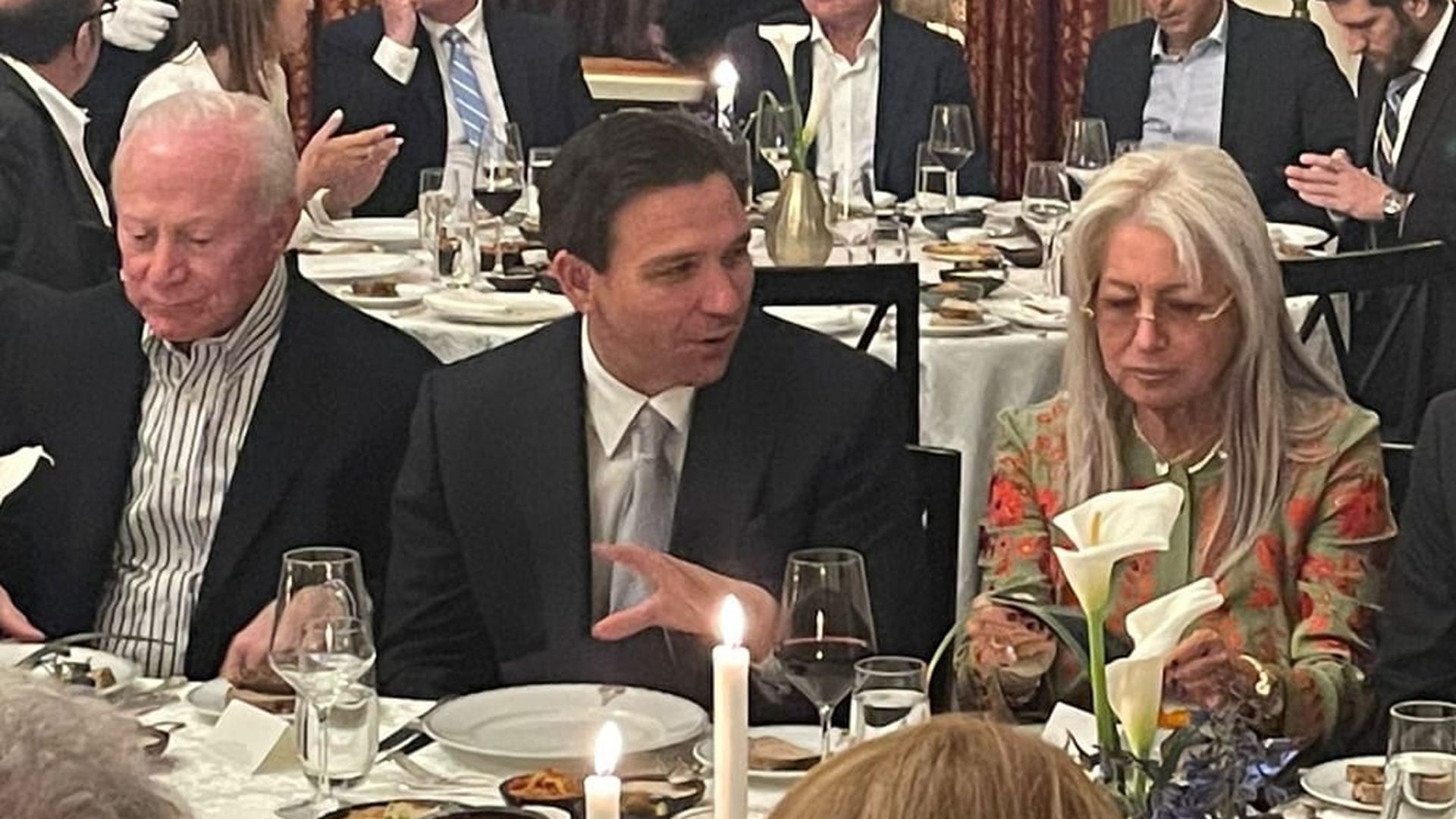 Florida Gov. Ron DeSantis sits between Miriam Adelson and Larry Mizel at a dinner in Jerusalem.