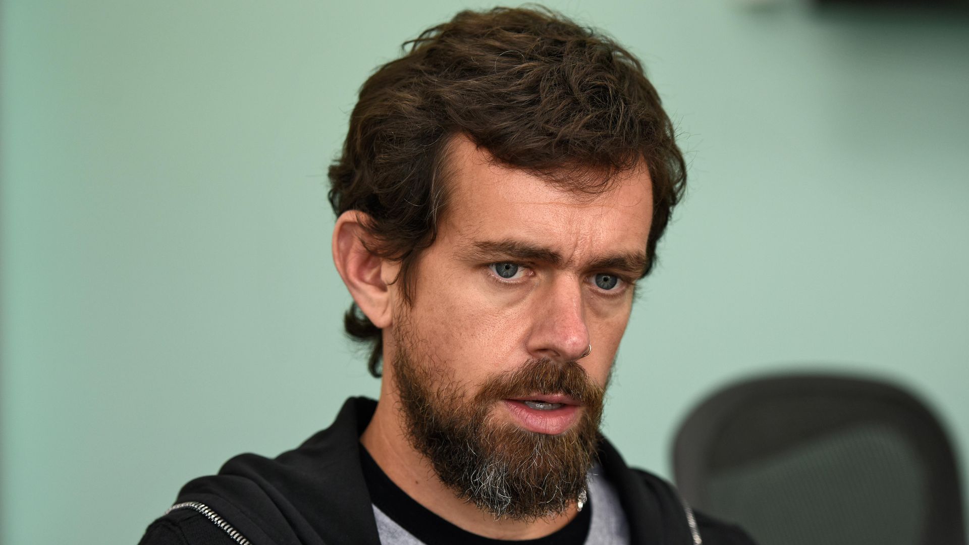 In this image, Dorsey is speaking while wearing a shirt and a hoodie.