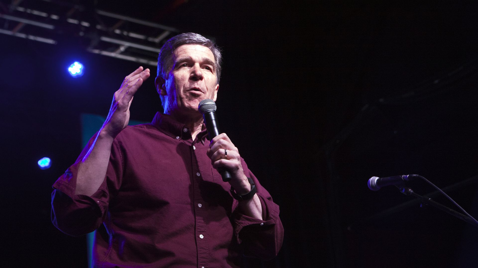 Roy Cooper speaks into a microphone
