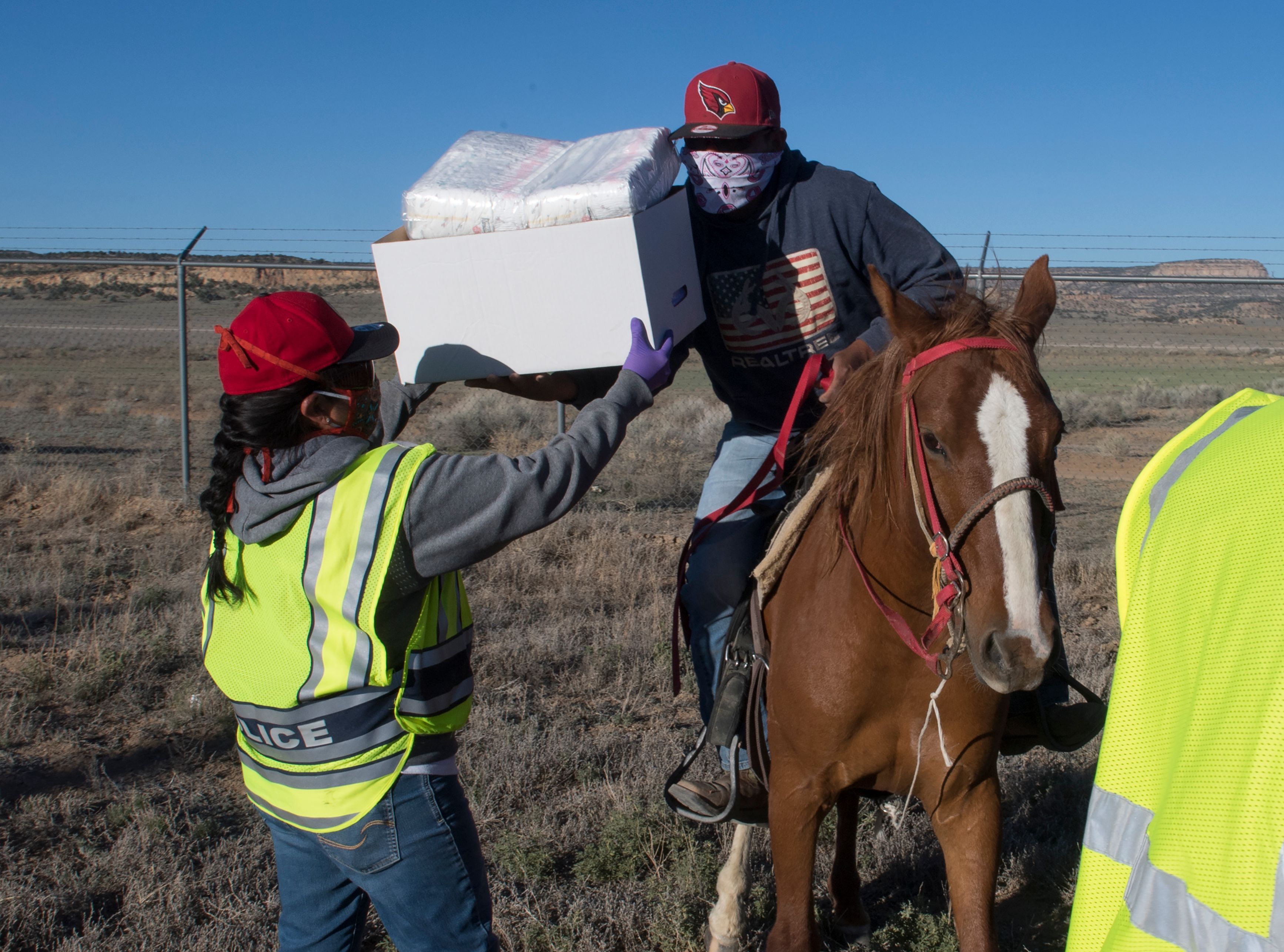 Native Americans of the Navajo Nation pick up supplies on horses at a food bank set up at the Navajo Nation town of Casamero Lake in New Mexico on May 20