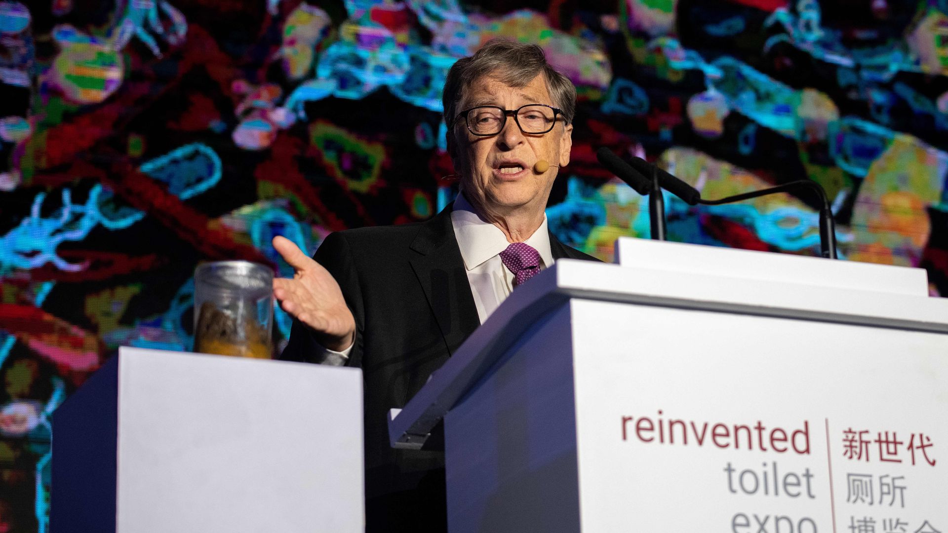 Microsoft founder Bill Gates (R) talks next to a container (L) with human feces during the 'reinvented toilet expo' in Beijing on November 6, 2018.