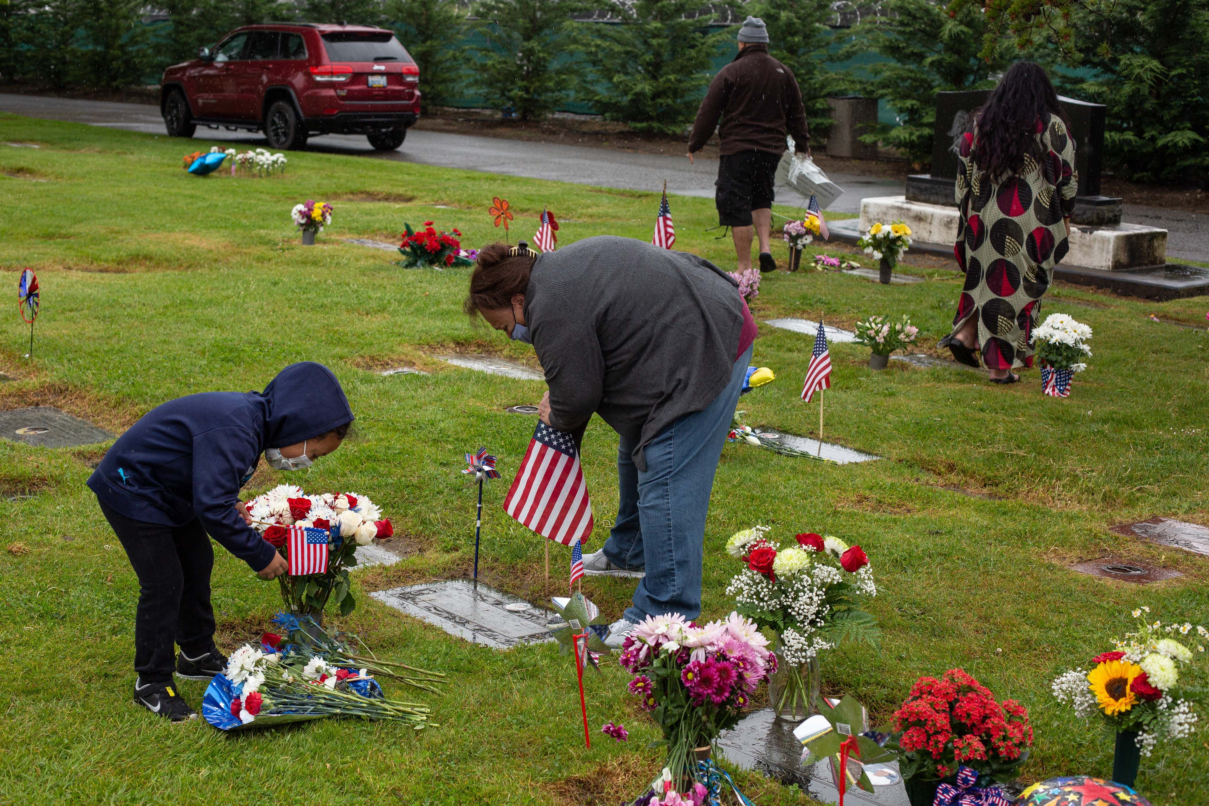 Decorating grave sites for family members on Memorial Day at Washington Memorial Park on May 25