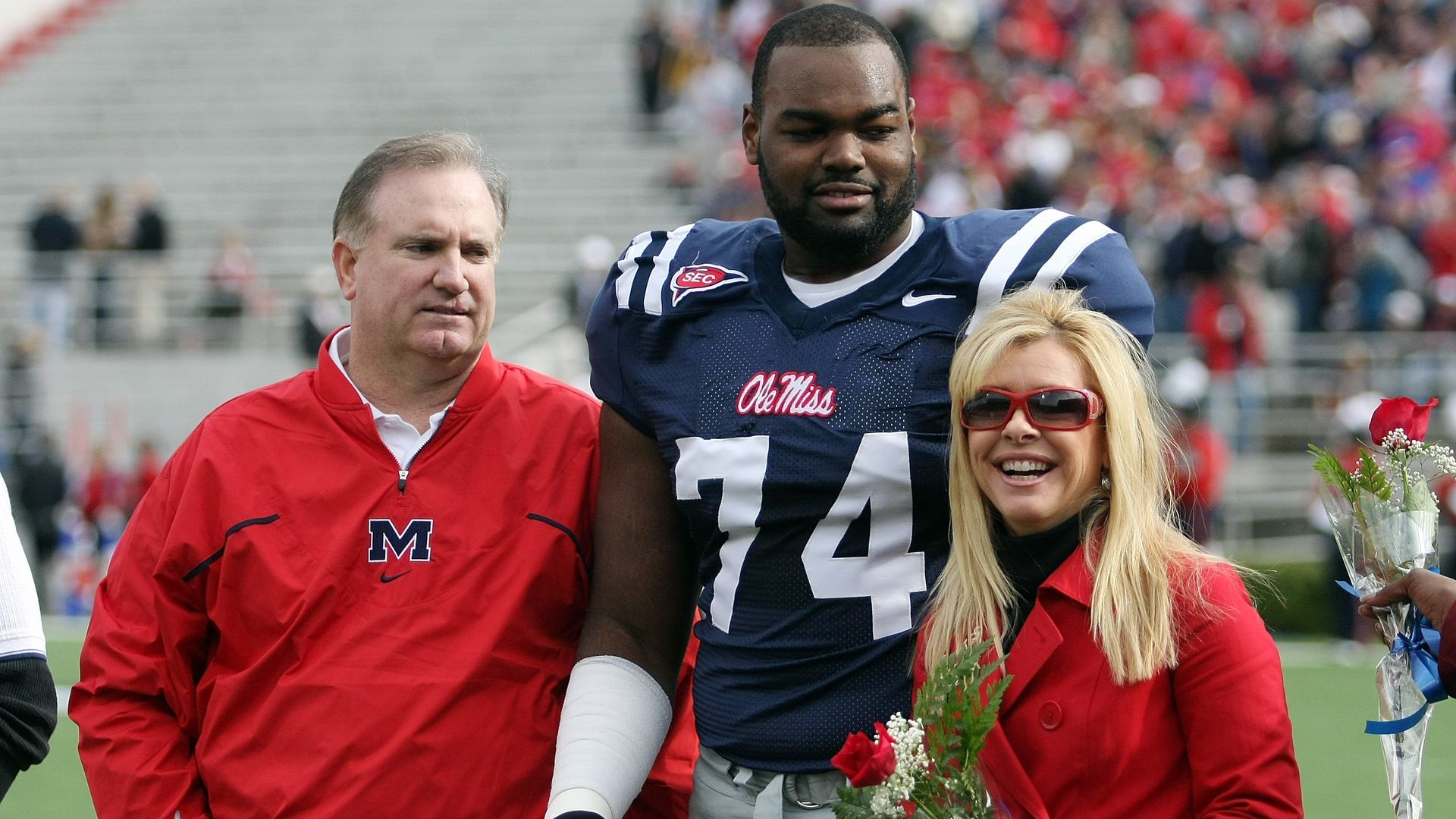Michael Oher with Sean and Leigh Anne Tuohy on a football field in Oxford, Mississippi, in 2008.