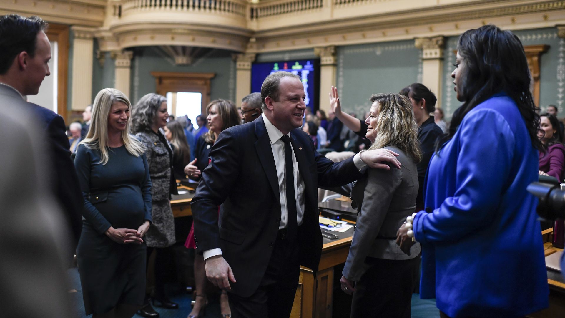 Gov. Jared Polis leaves the Colorado State House floor