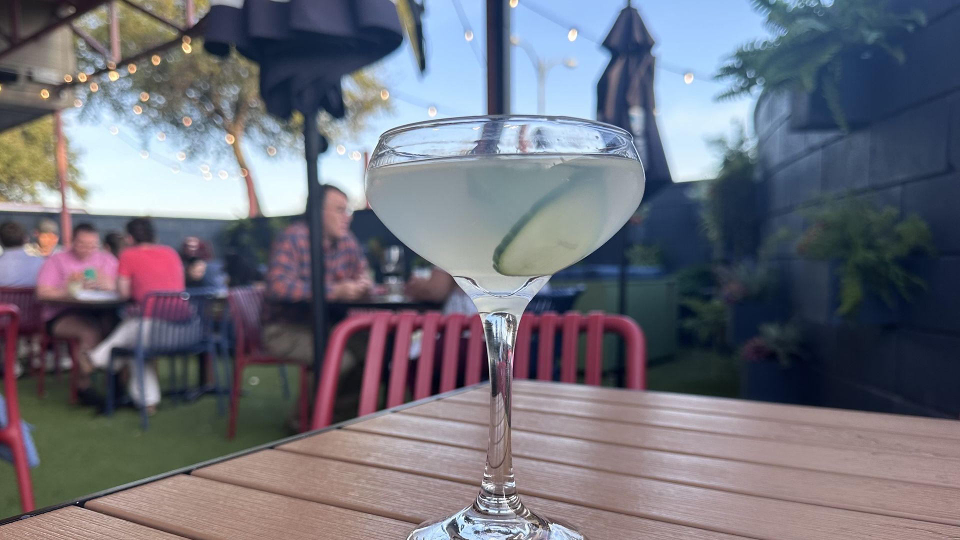 A photo of a cocktail in a coupe with a cucumber in it 
