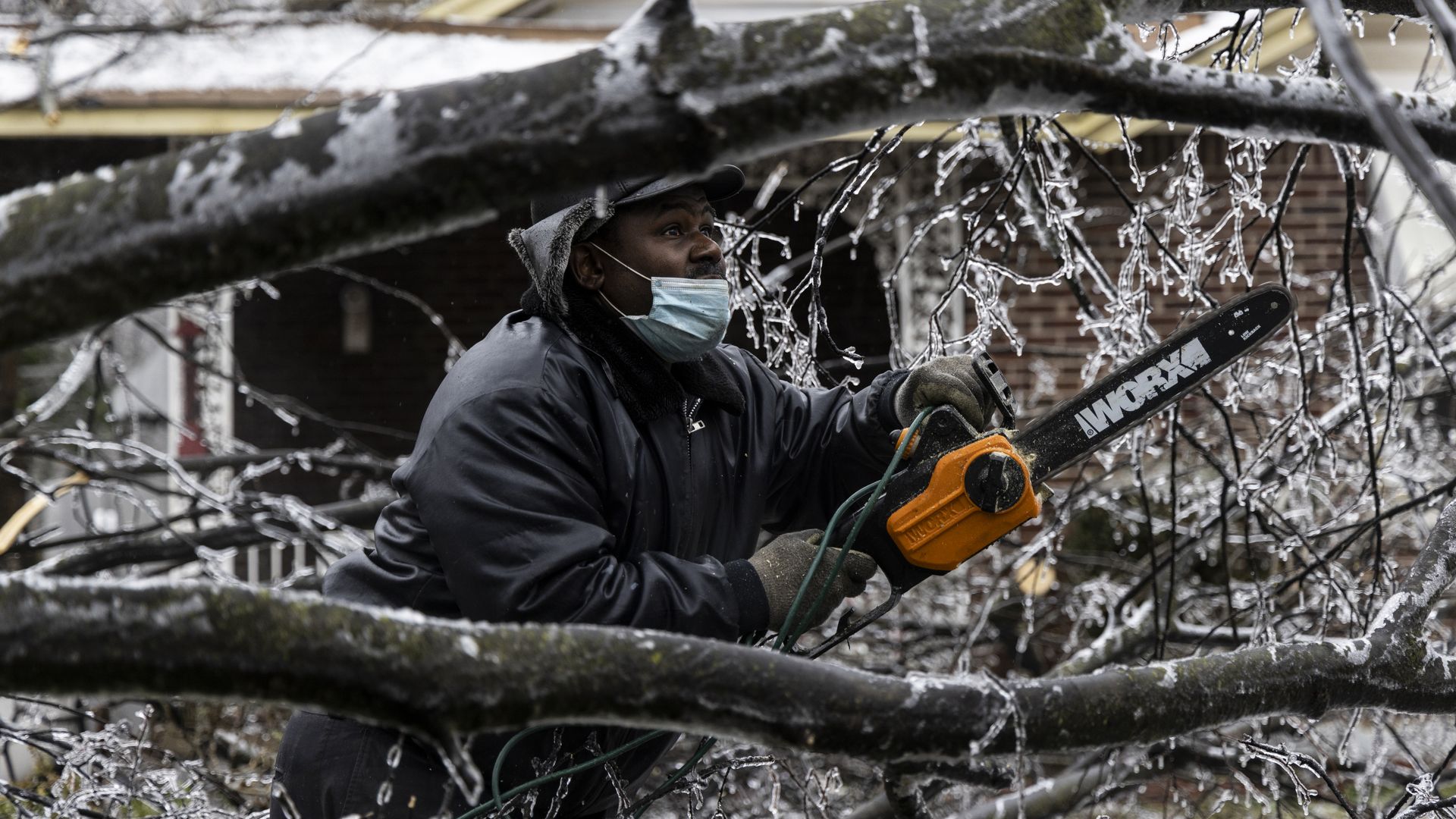 Edward Caldwell works to clear a downed tree at his moms house on February 3, 2022 in Memphis, Tenn.