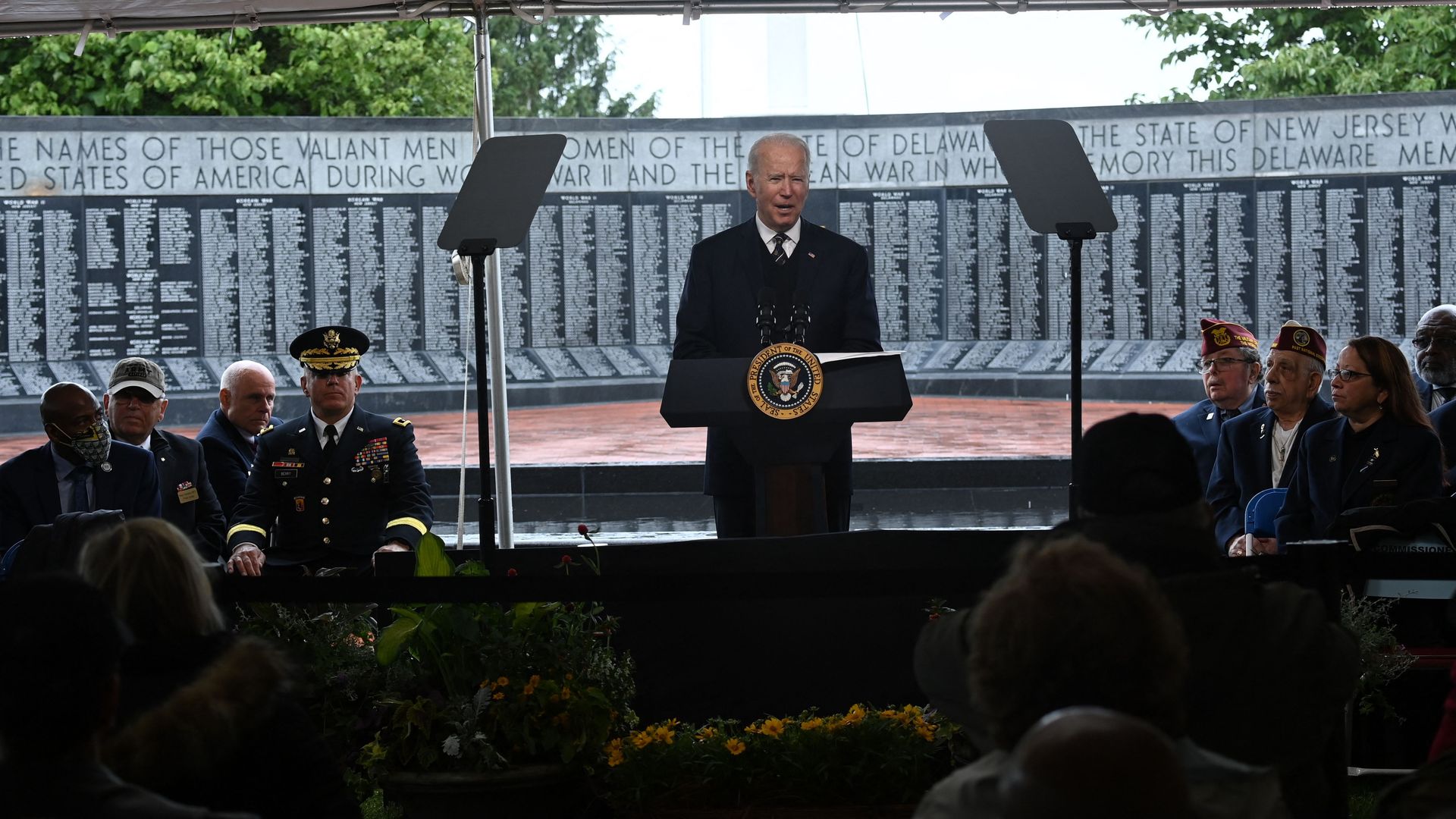 President Biden is flanked by veterans and two teleprompters as he delivers a speech at Veterans Memorial Park in New Castle, Delaware