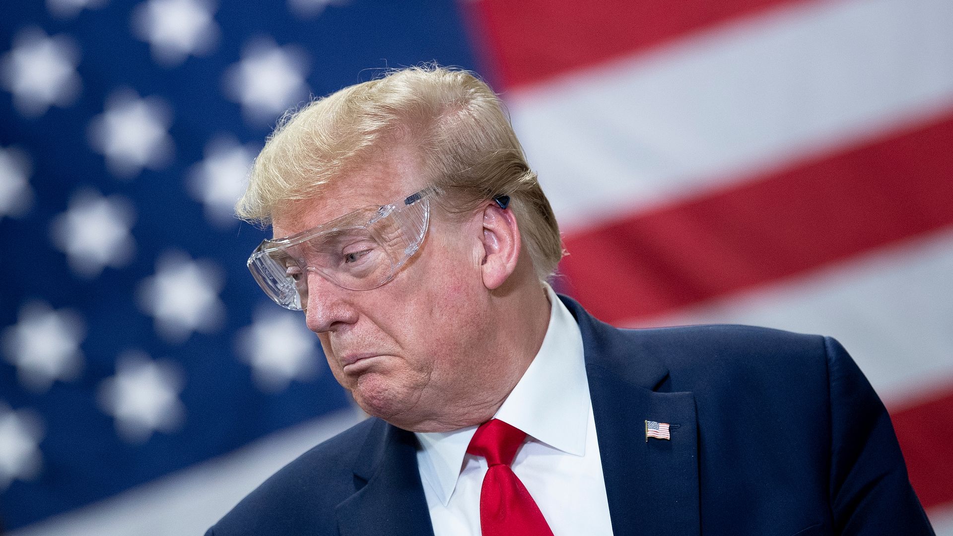President Trump wears goggles and gives an animated expression during a tour of a mask factory