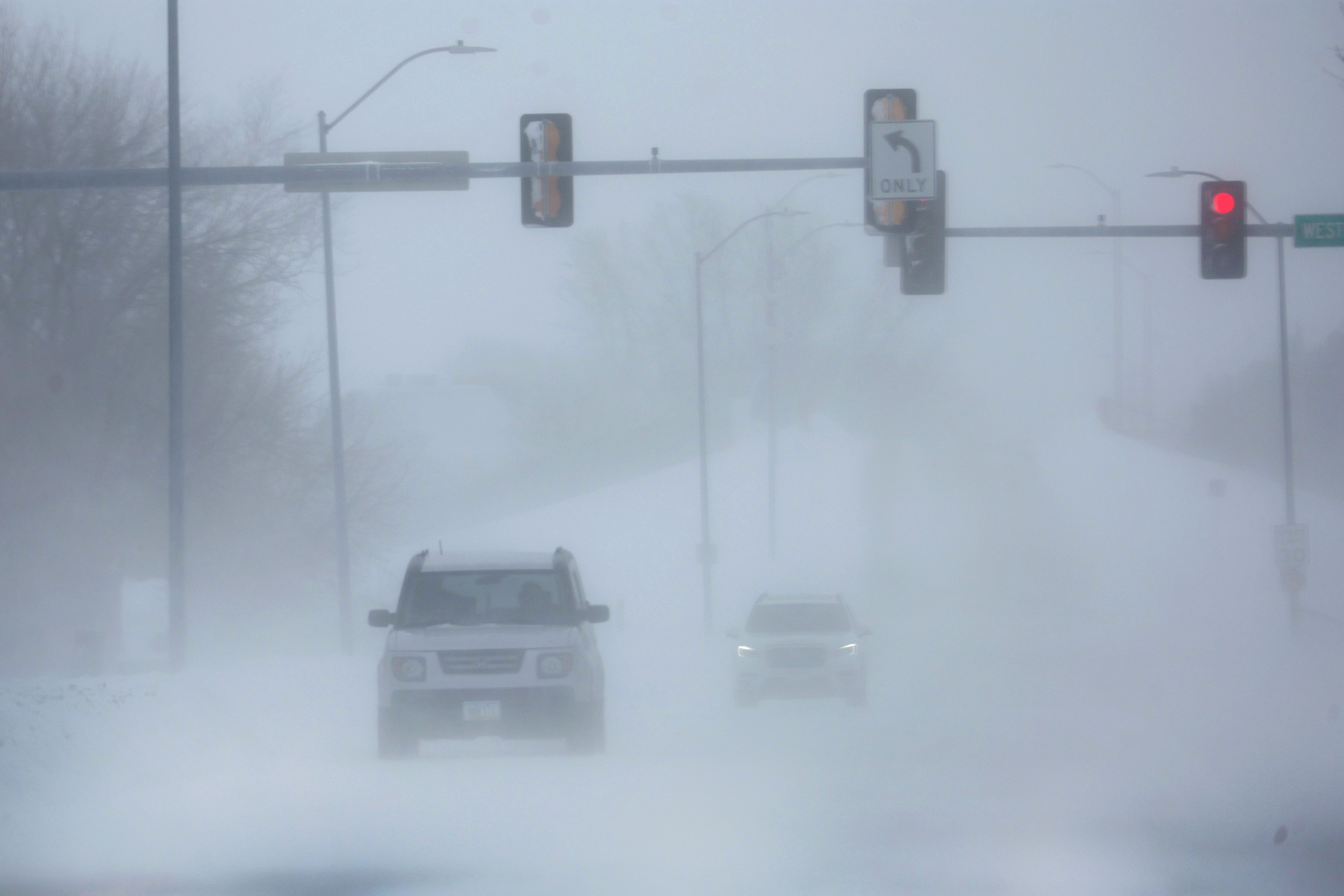  Motorists navigate through blowing snow during a cold windy day on January 13, 2024 in West Des Moines, Iowa. 