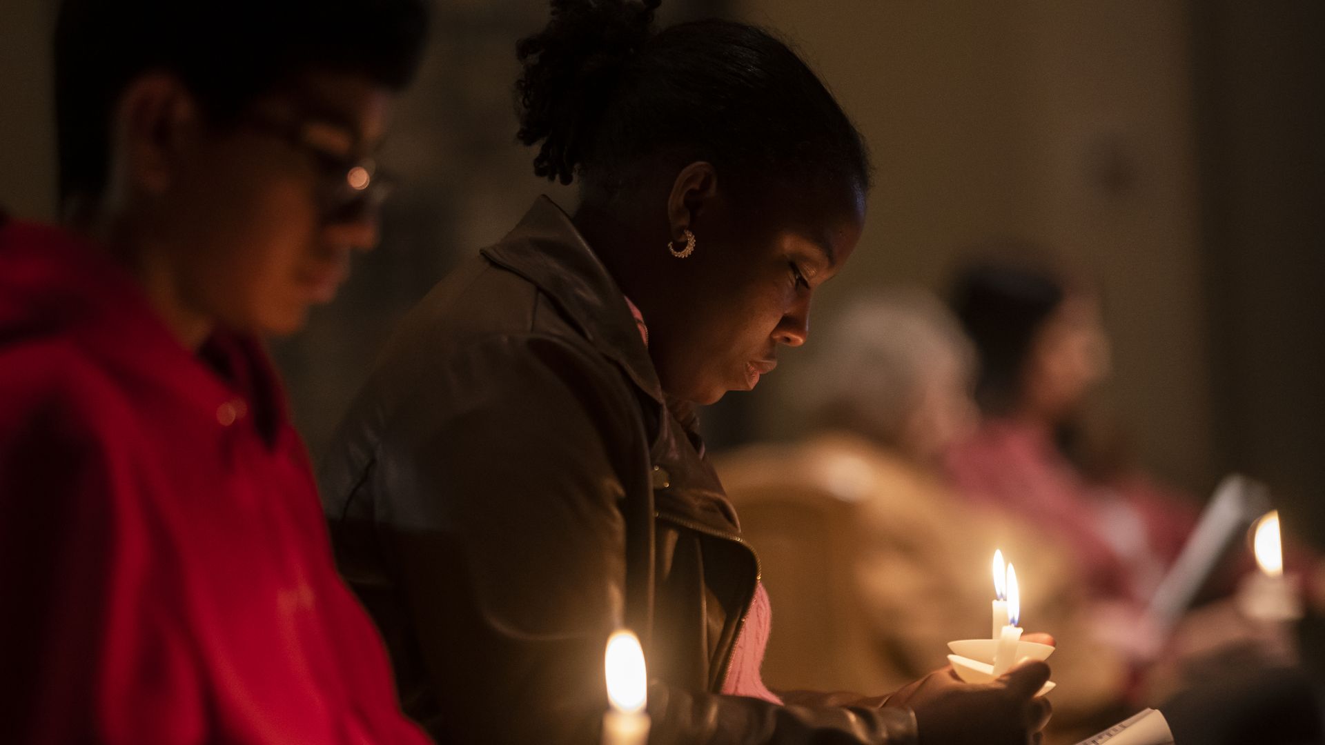 Alexandra Bernier listens to a prayer during a vigil at St. Thomas Episcopal Church for those killed in a fatal shooting at a Walmart on November 23, 2022 in Chesapeake, Virginia