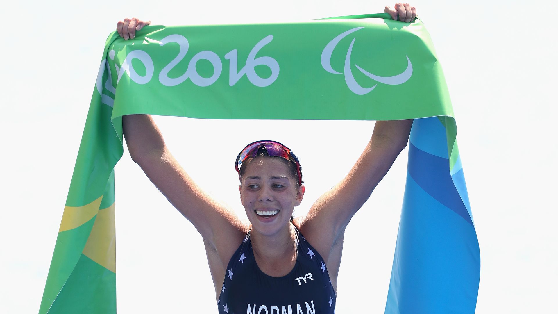 Grace Norman holds a championship banner above her head.