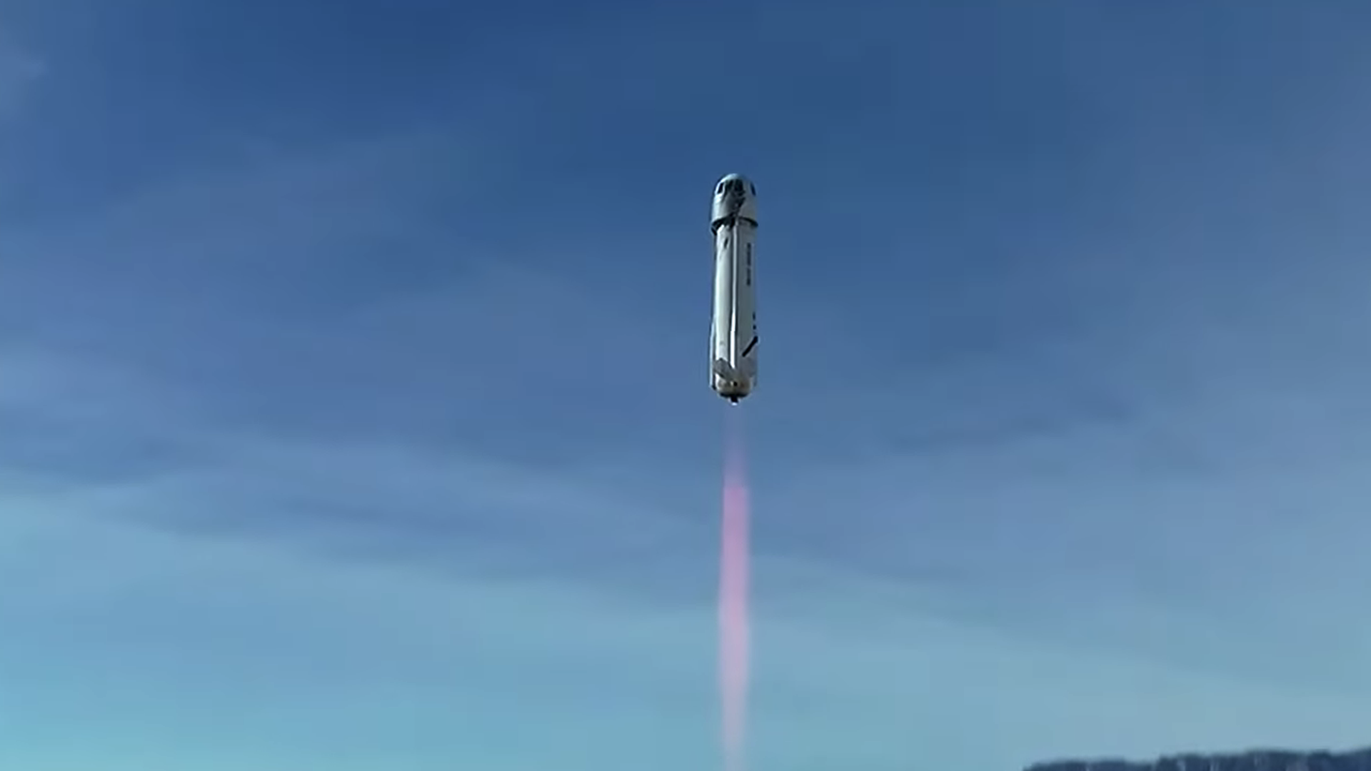 A Blue Origin rocket takes flight in into blue skies above Texas