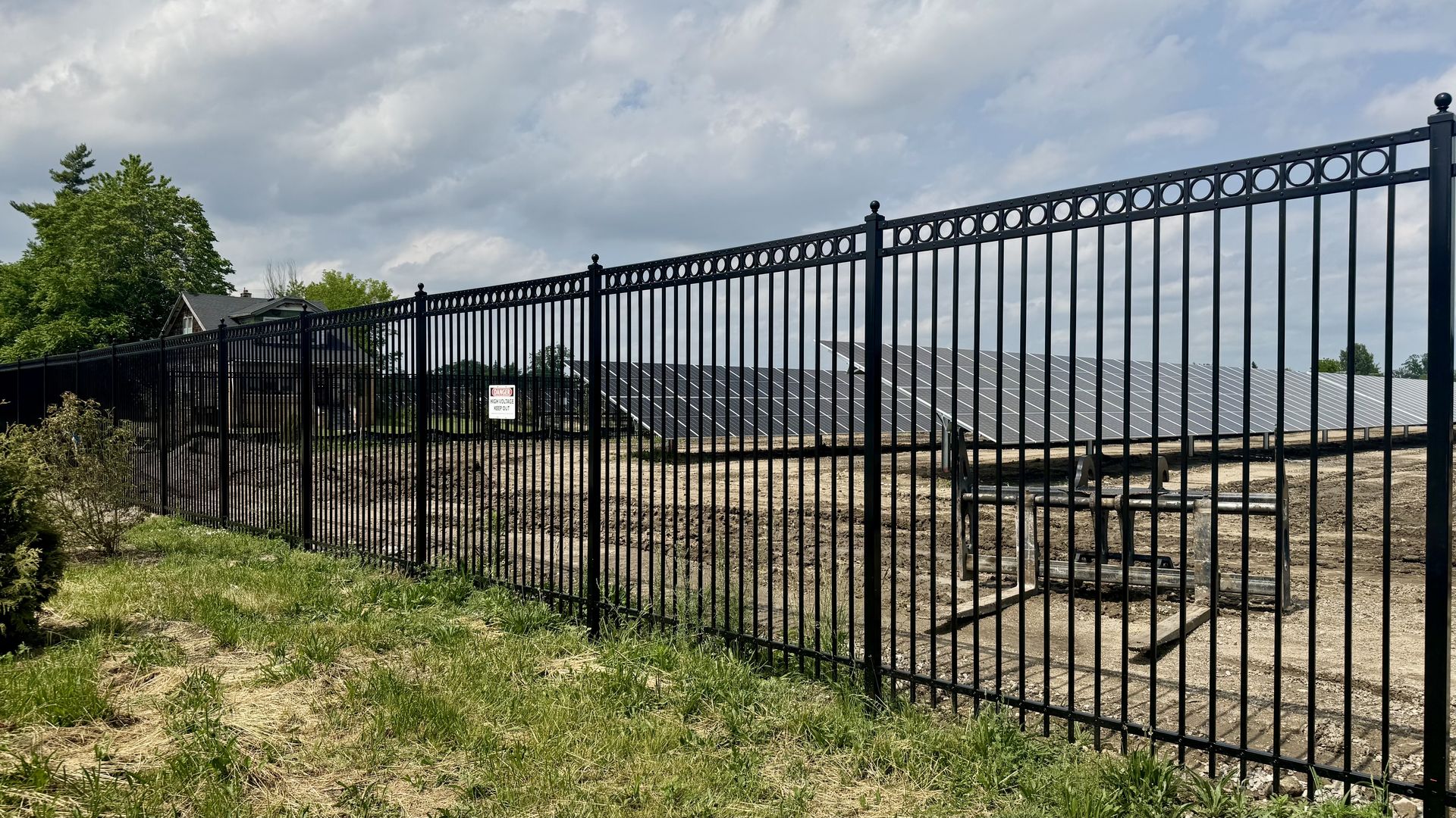 Solar panels on a construction site behind a fence