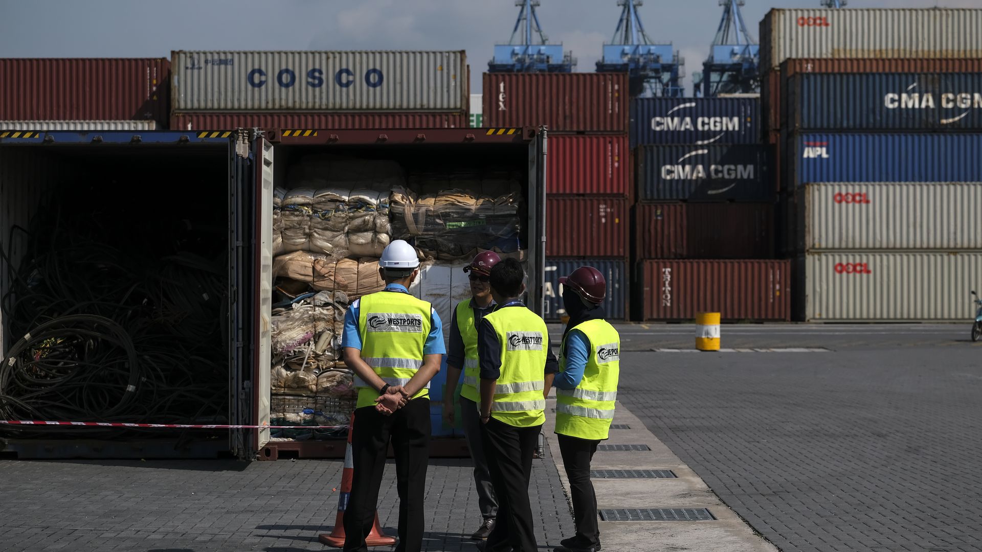 Workers in front of containers filled with plastic waste at a port in Selangor, Malaysia in May 2019.
