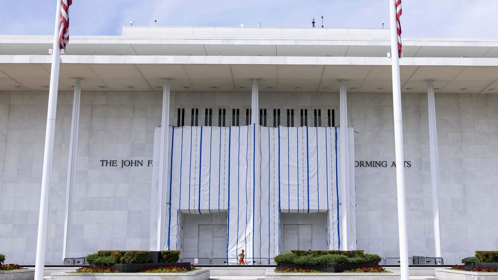 A tarp can be seen over the front of the Kennedy Center in this daytime photo.
