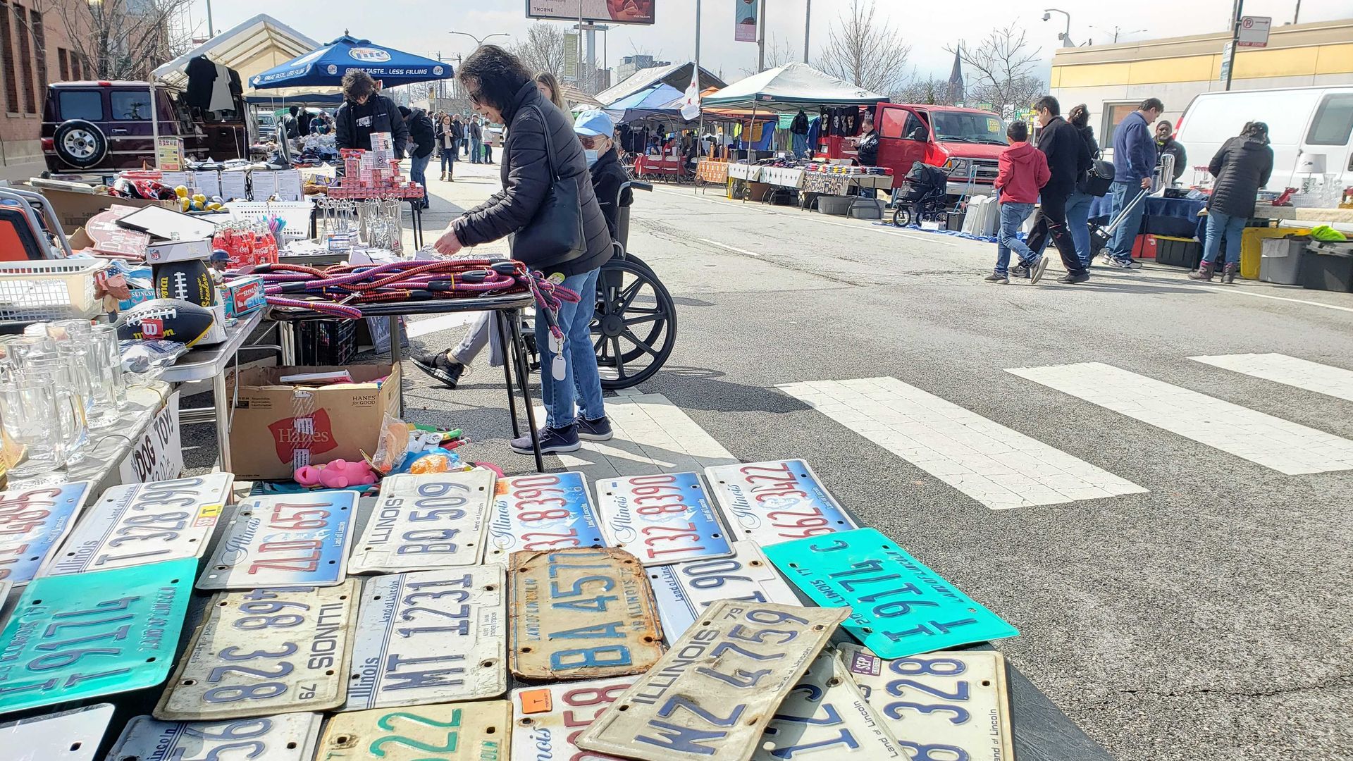 Photo of a street festival and a table full of old license plates.