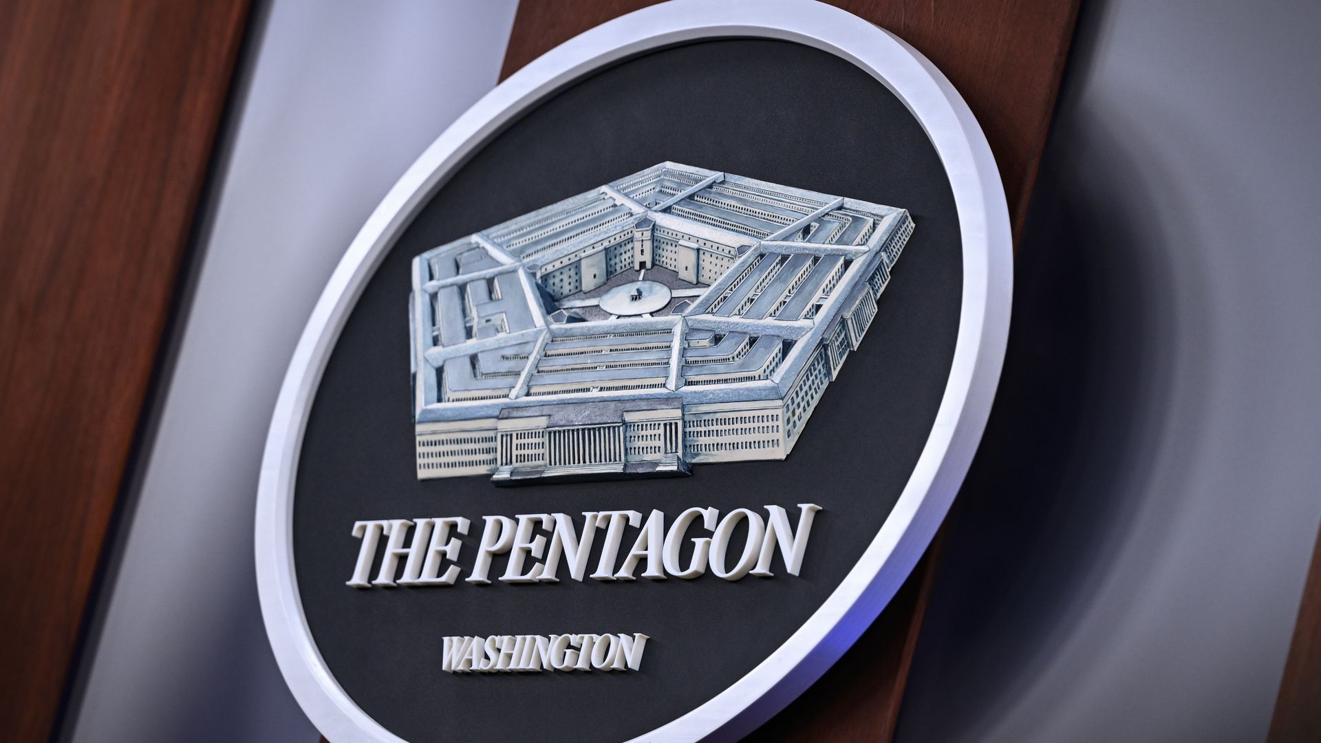 The Pentagon seal hangs on a wall.