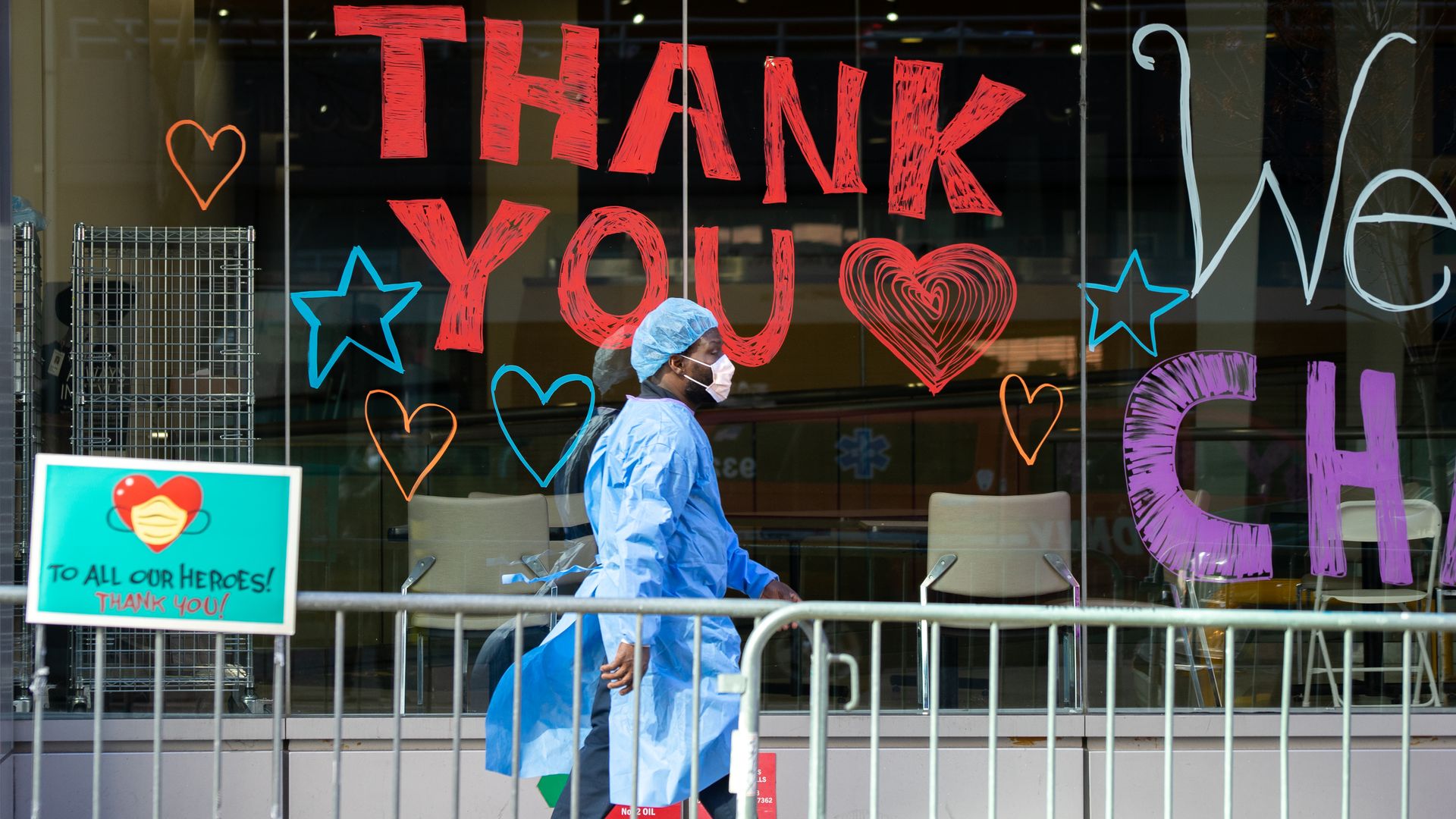 A health care worker on the side walk as he wears personal protective equipment