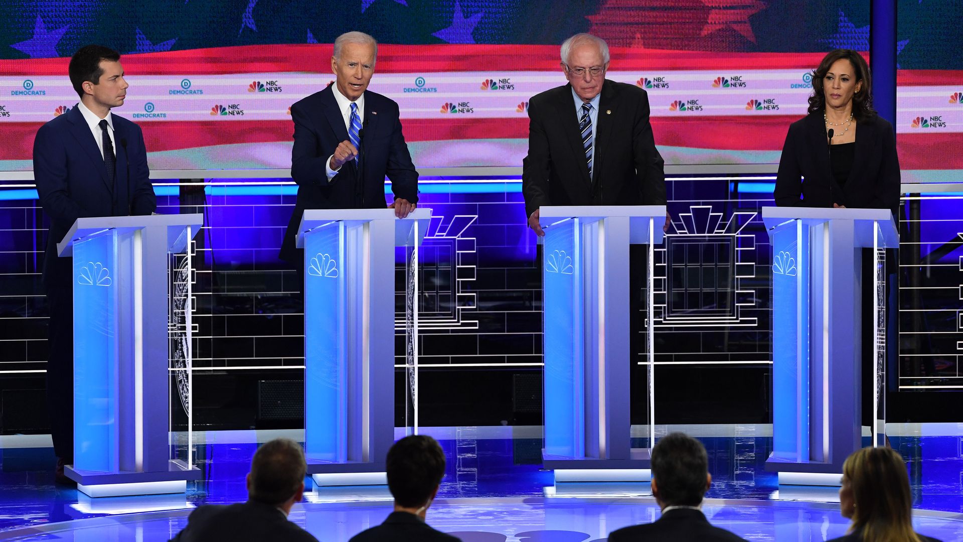 In this image, Buttigieg, Biden, Bernie and Harris stand at separate podiums on the debate stage.