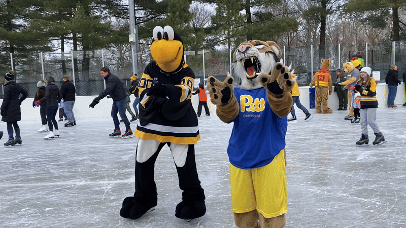 The Pittsburgh Penguins mascot Iceburgh and the University of Pittsburgh at Greensburg mascot Bruiser Bobcat wave.