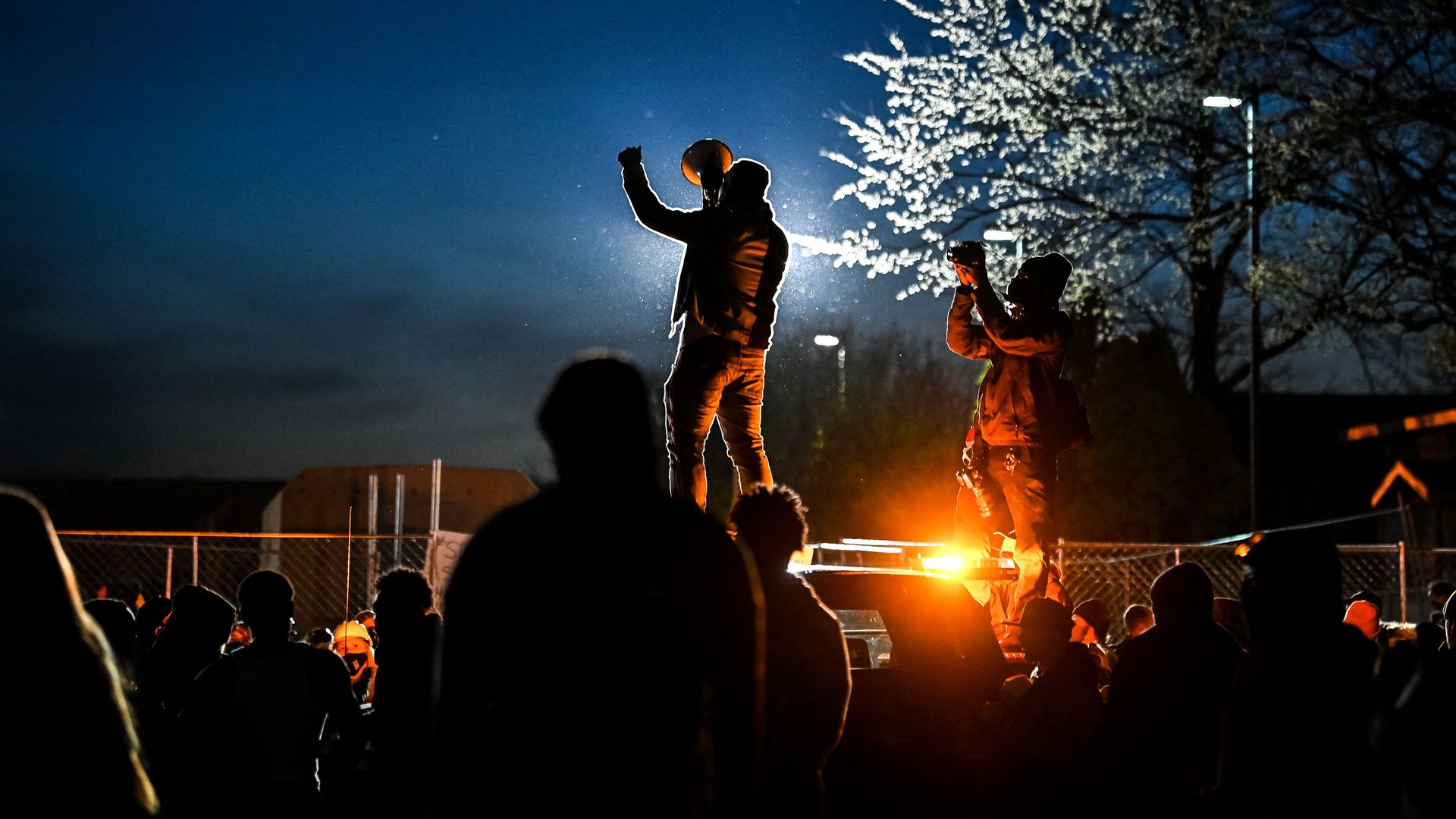 Picture of demonstrators standing on and holding megaphones 