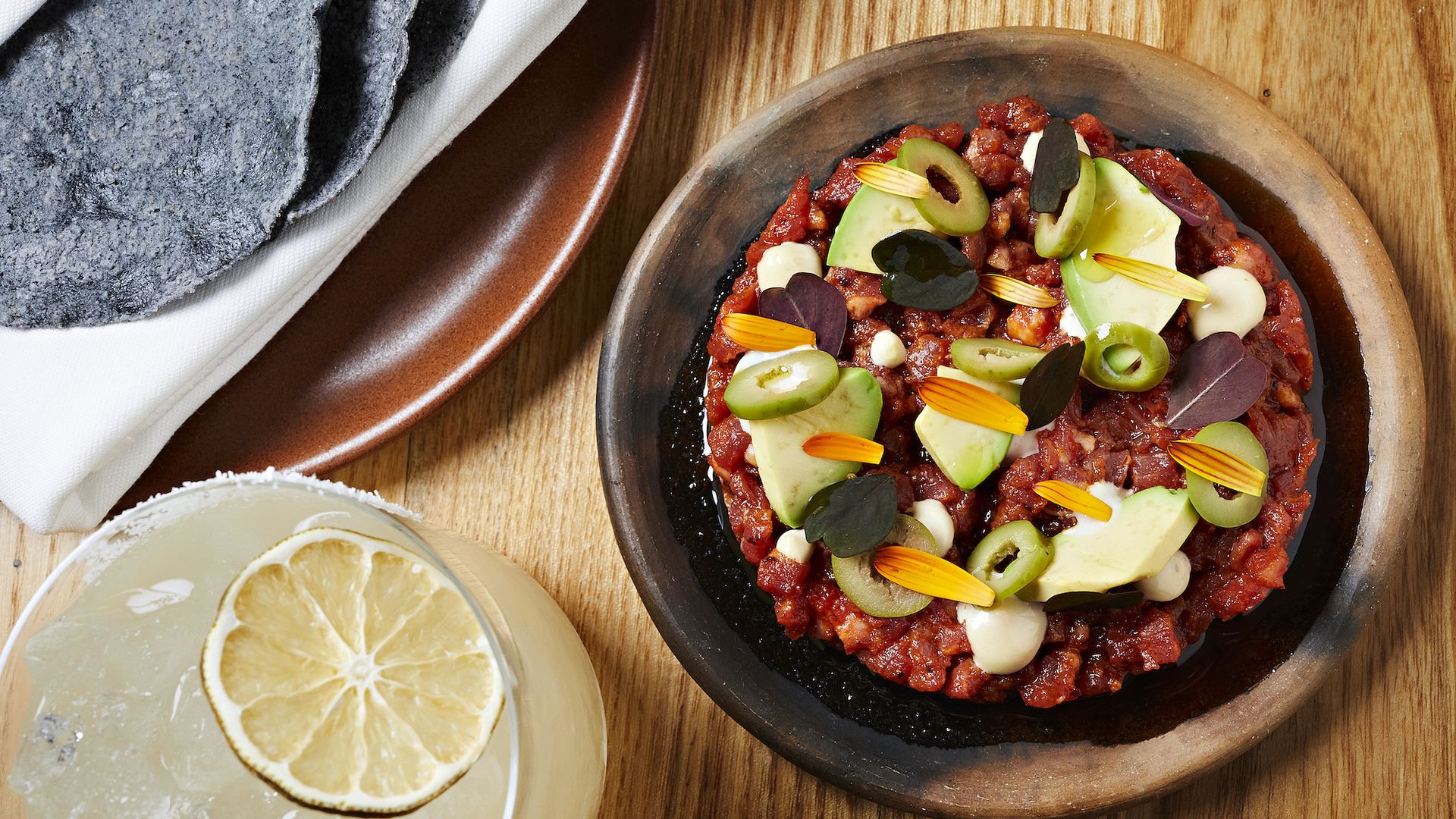 Beef tartare and a margarita on a wooden table