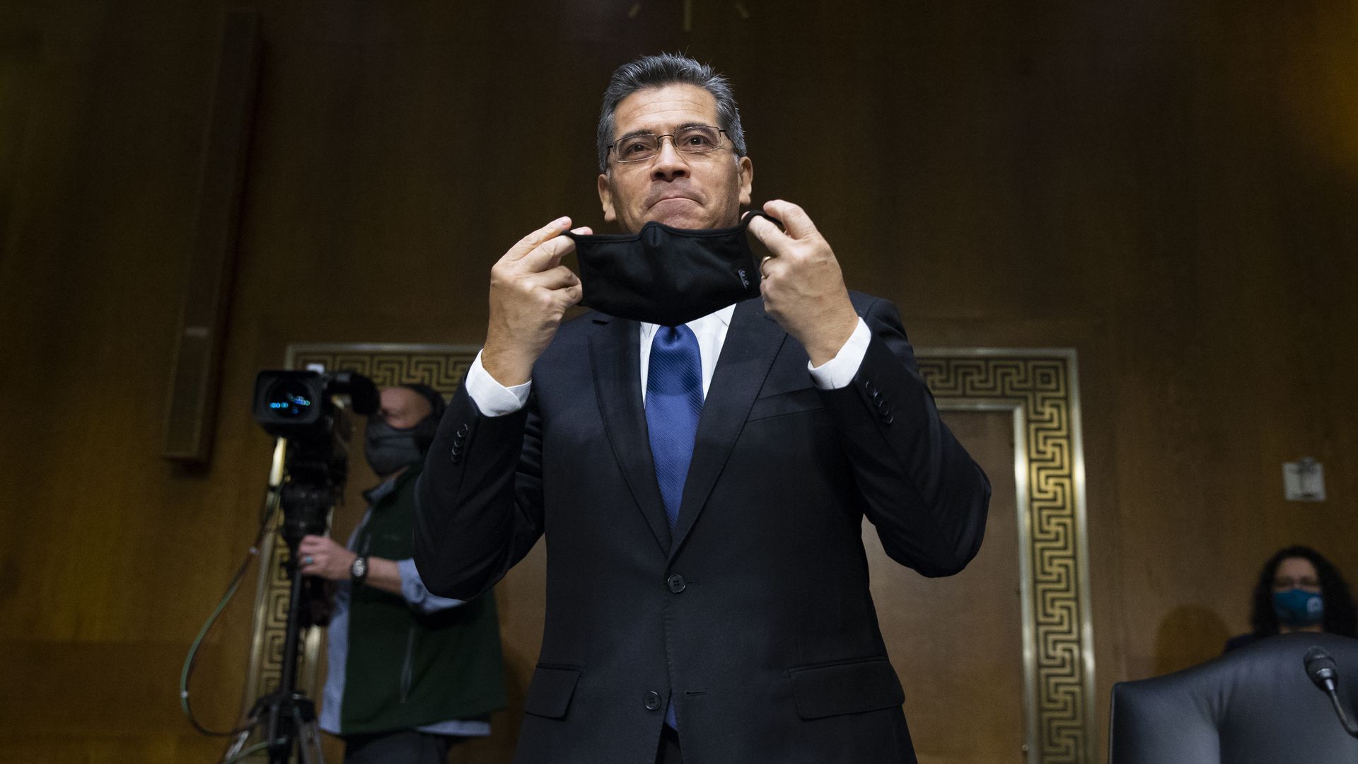 Picture of Xavier Becerra putting on a mask