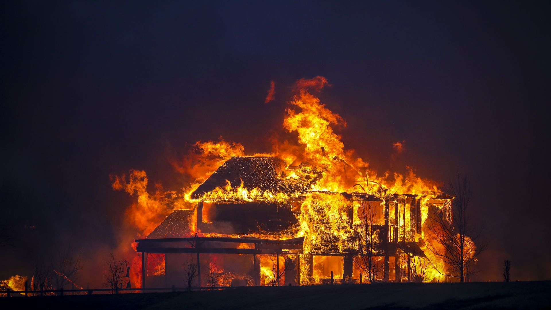 A home burns after a fast moving wildfire swept through the area in the Centennial Heights neighborhood of Louisville.