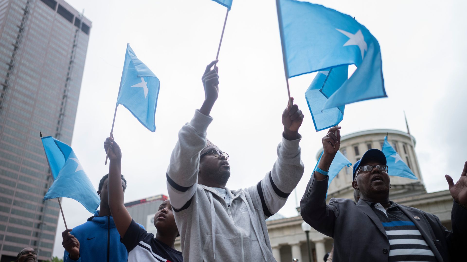 Somalians wave flags in front of the Ohio Statehouse.