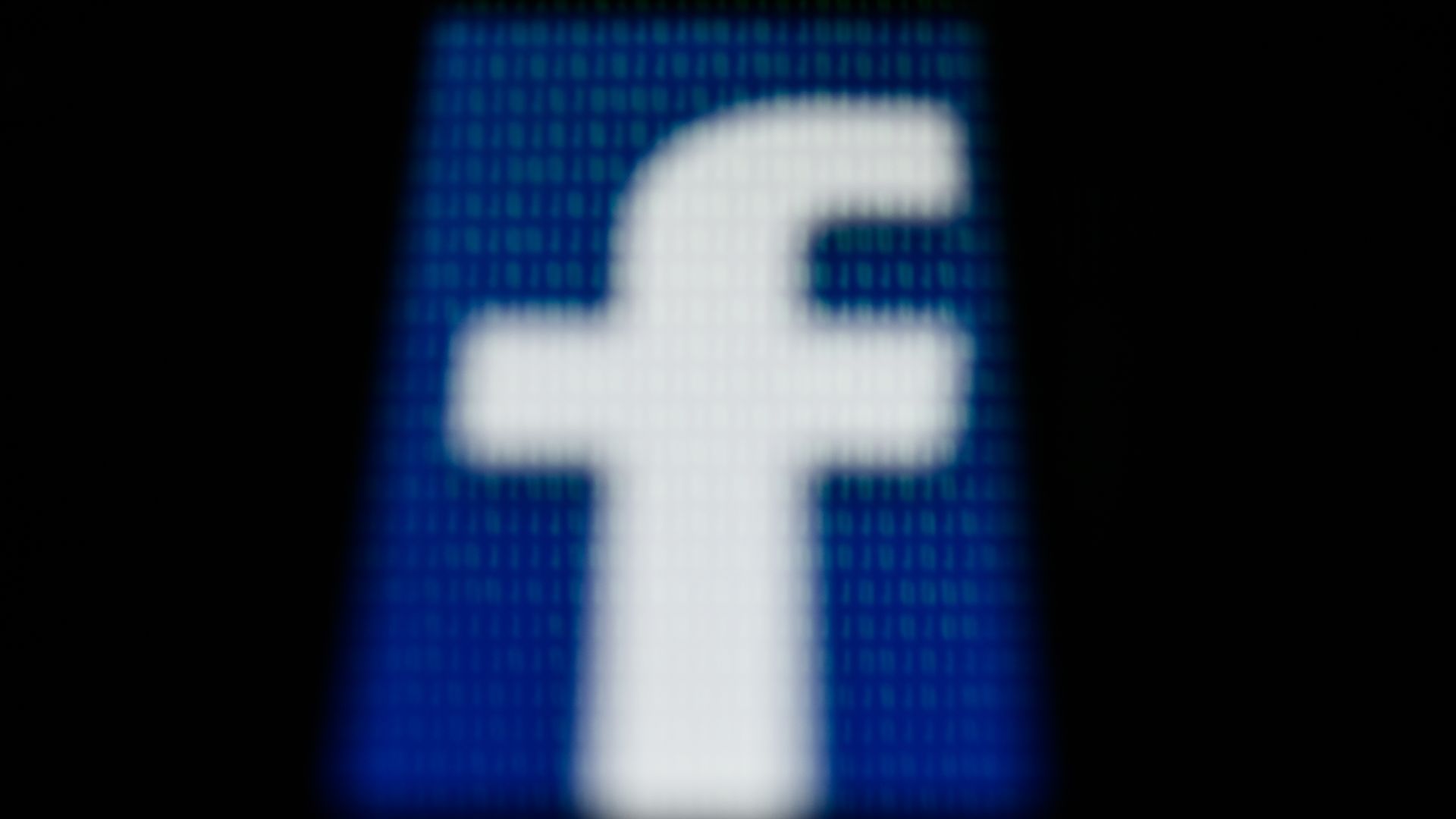 In this image, the F of the Facebook logo is seen on a phone pixelated with numbers.