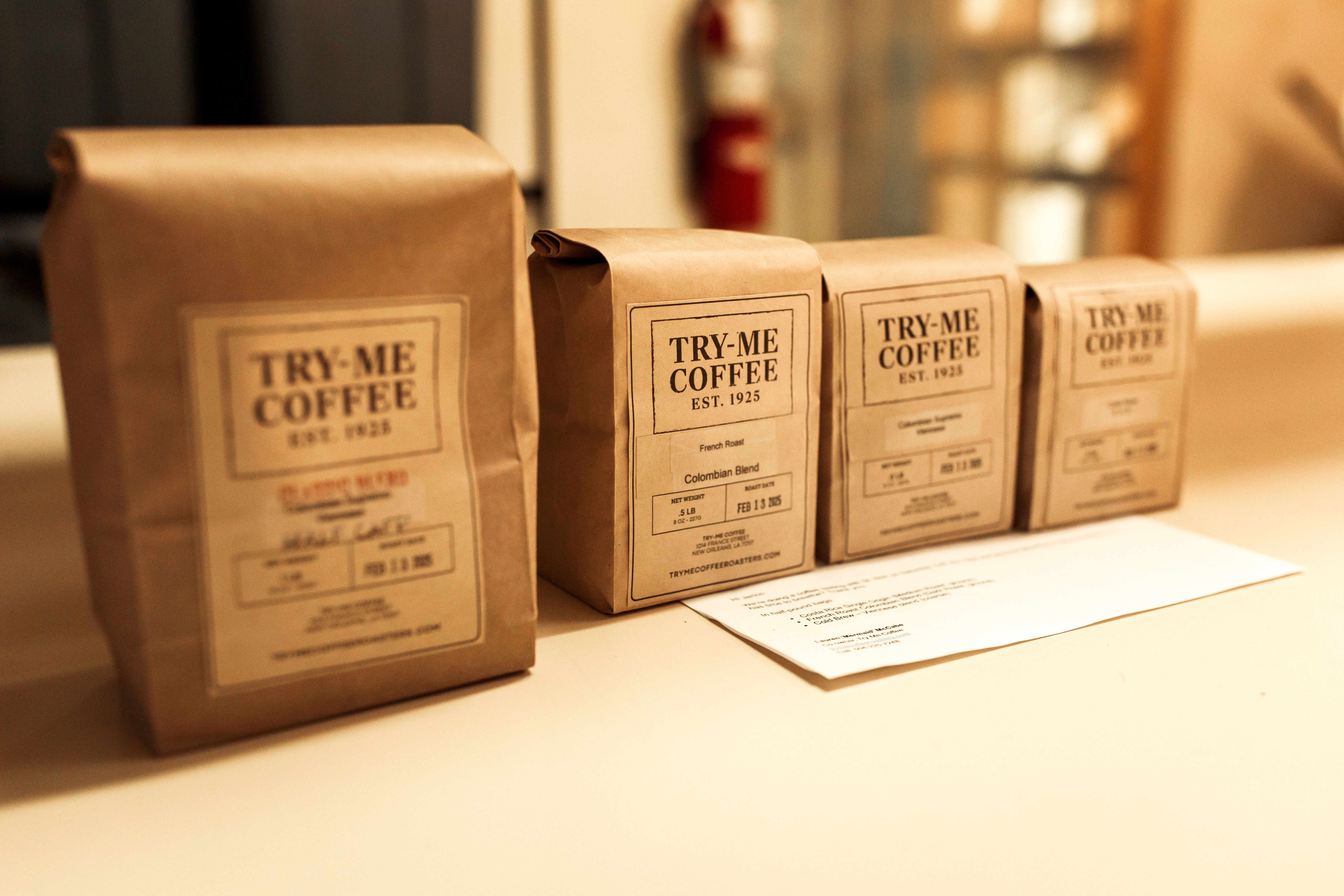 Four bags of coffee with a simple Try-Me Coffee label sit in a row.
