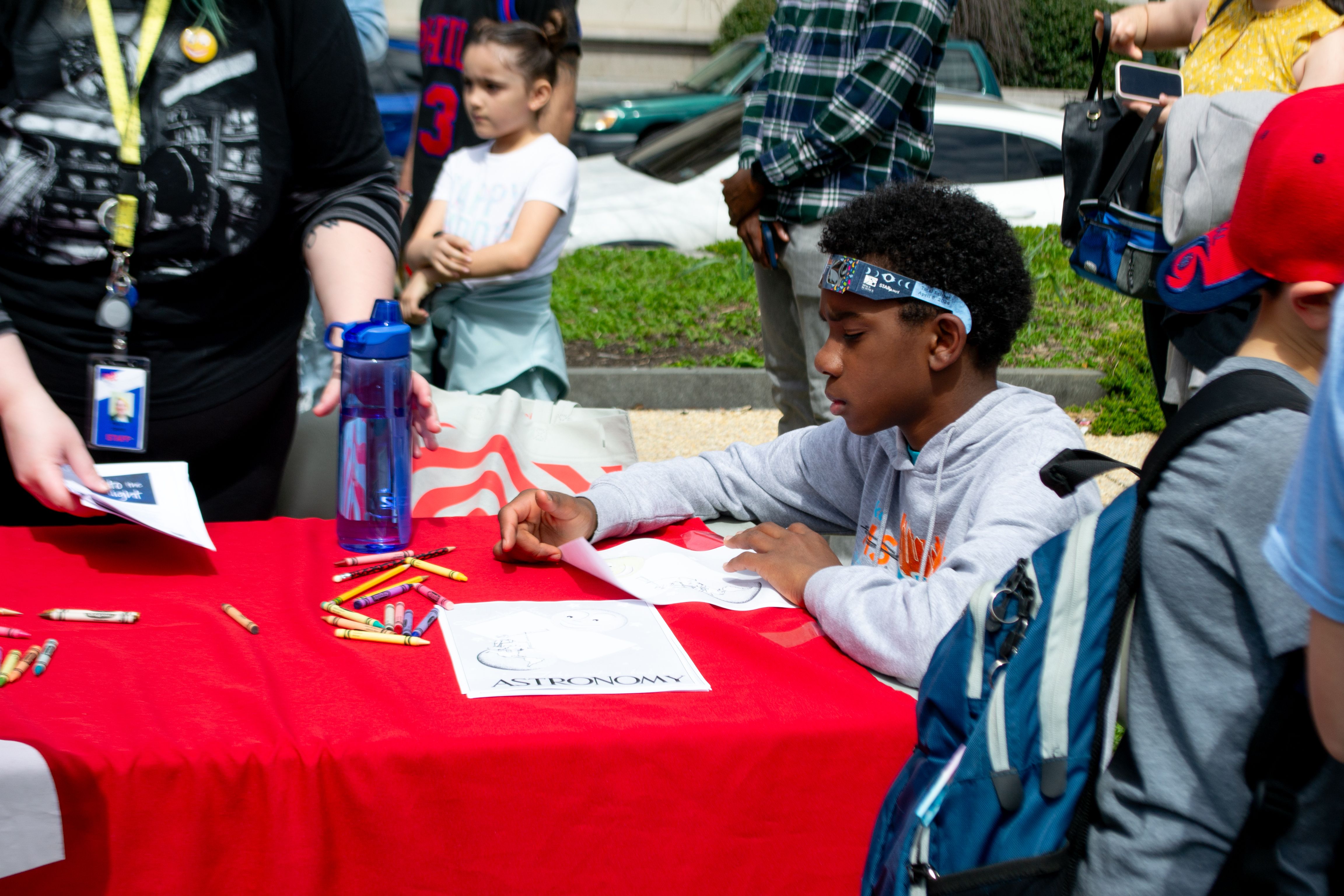 A child sits at a table looking at a piece of paper.