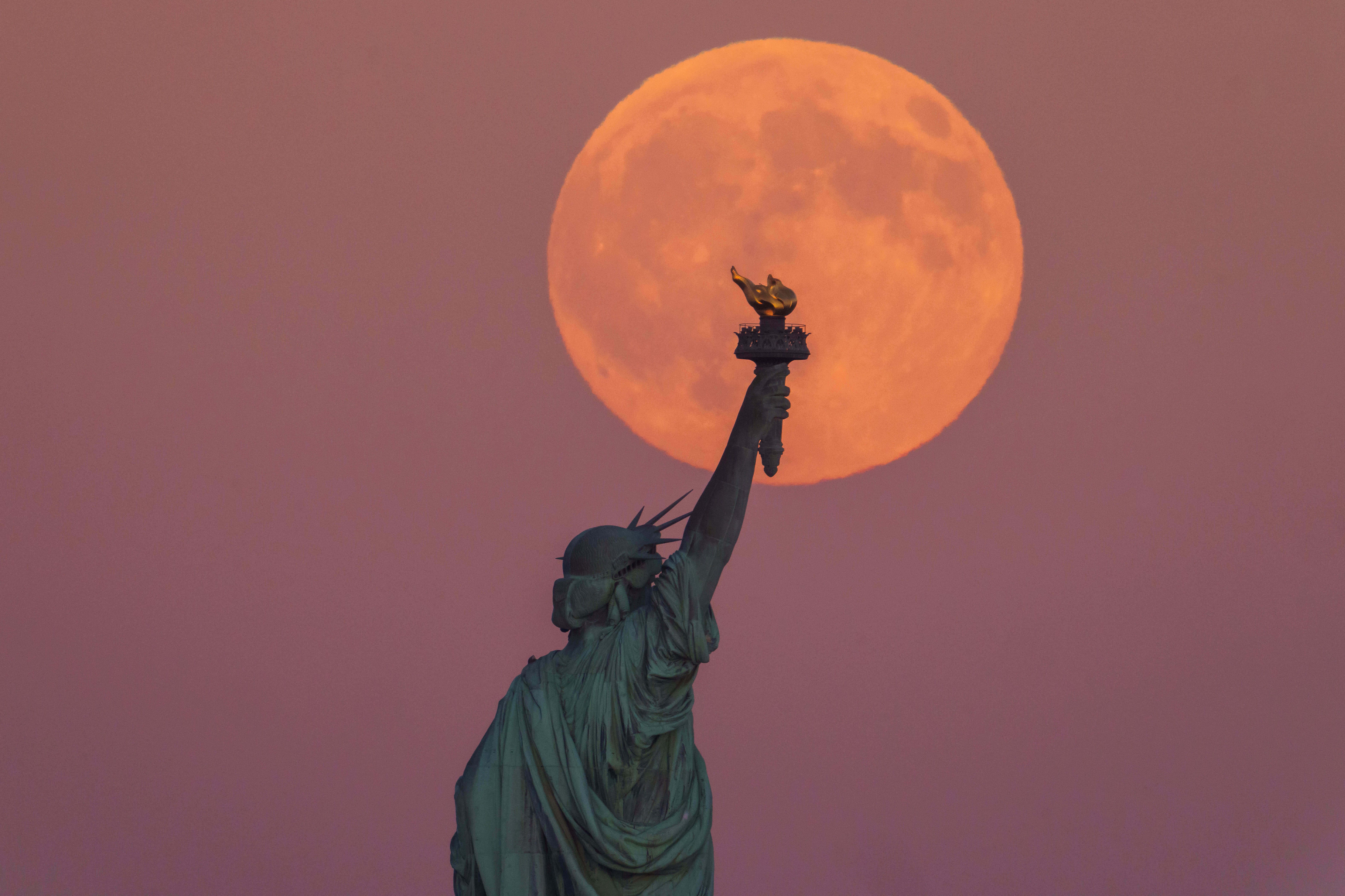 A supermoon seen last night over the Statue of Liberty.