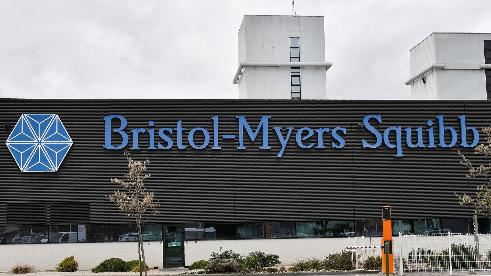 A manufacturing plant with the Bristol-Myers Squibb logo.