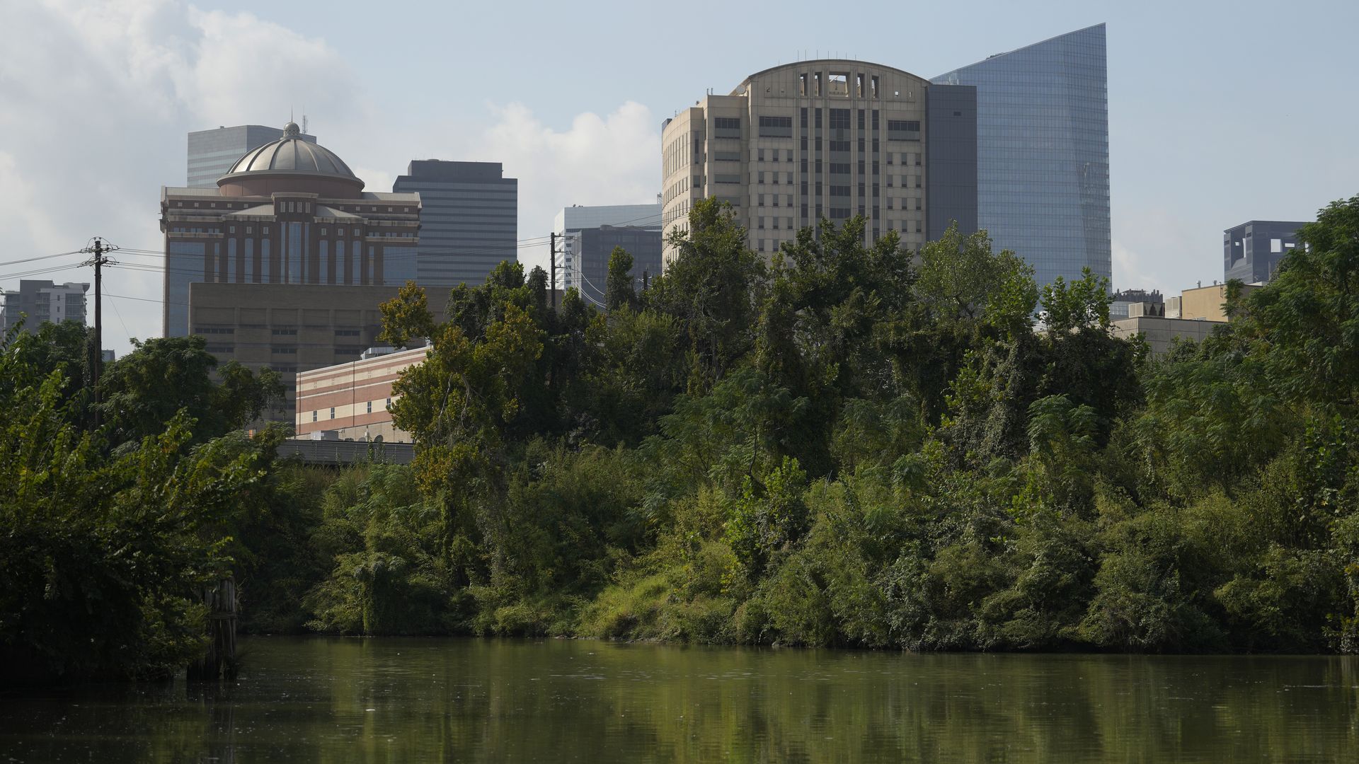 Photo of the Houston skyline and lush greenery along the bayou. 