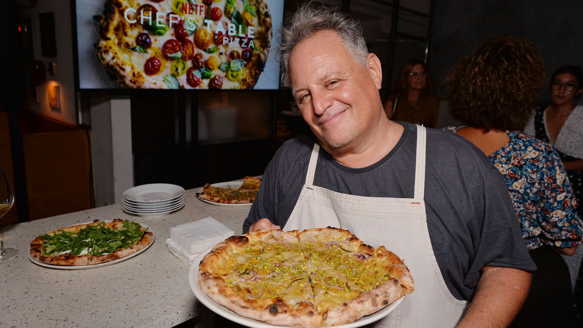 A man holding a pizza.