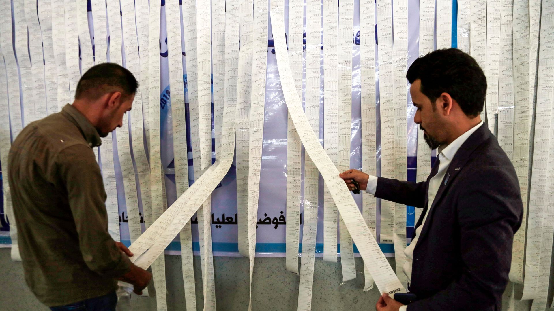 Iraqi electoral commission employees examine electronic counting machine print-outs in the central holy city of Najaf on May 13, 2018.