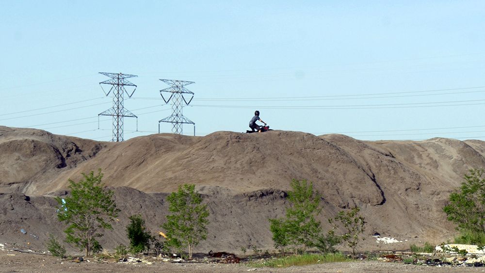 Photo of someone riding a dirt bike on top of a dirt hill 