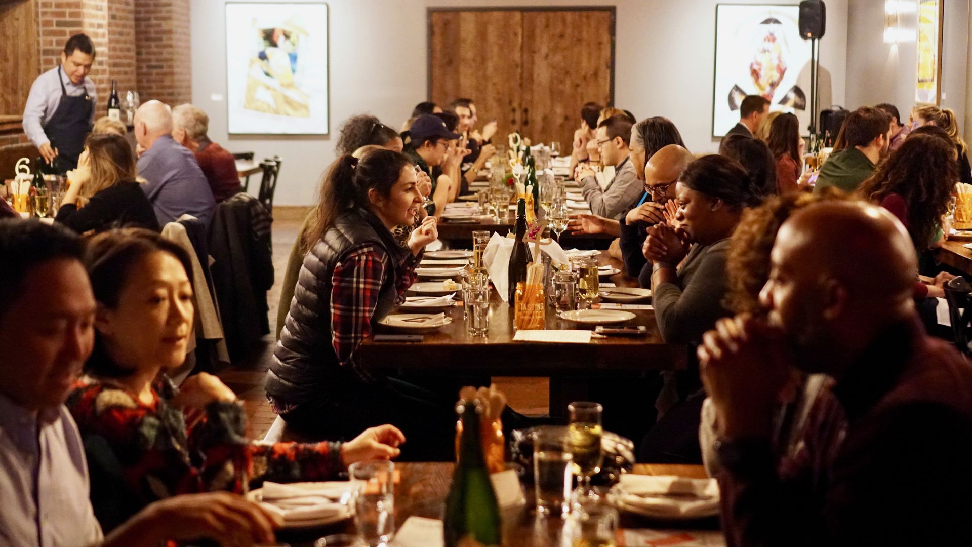 A group of people at a long table in a restaurant.