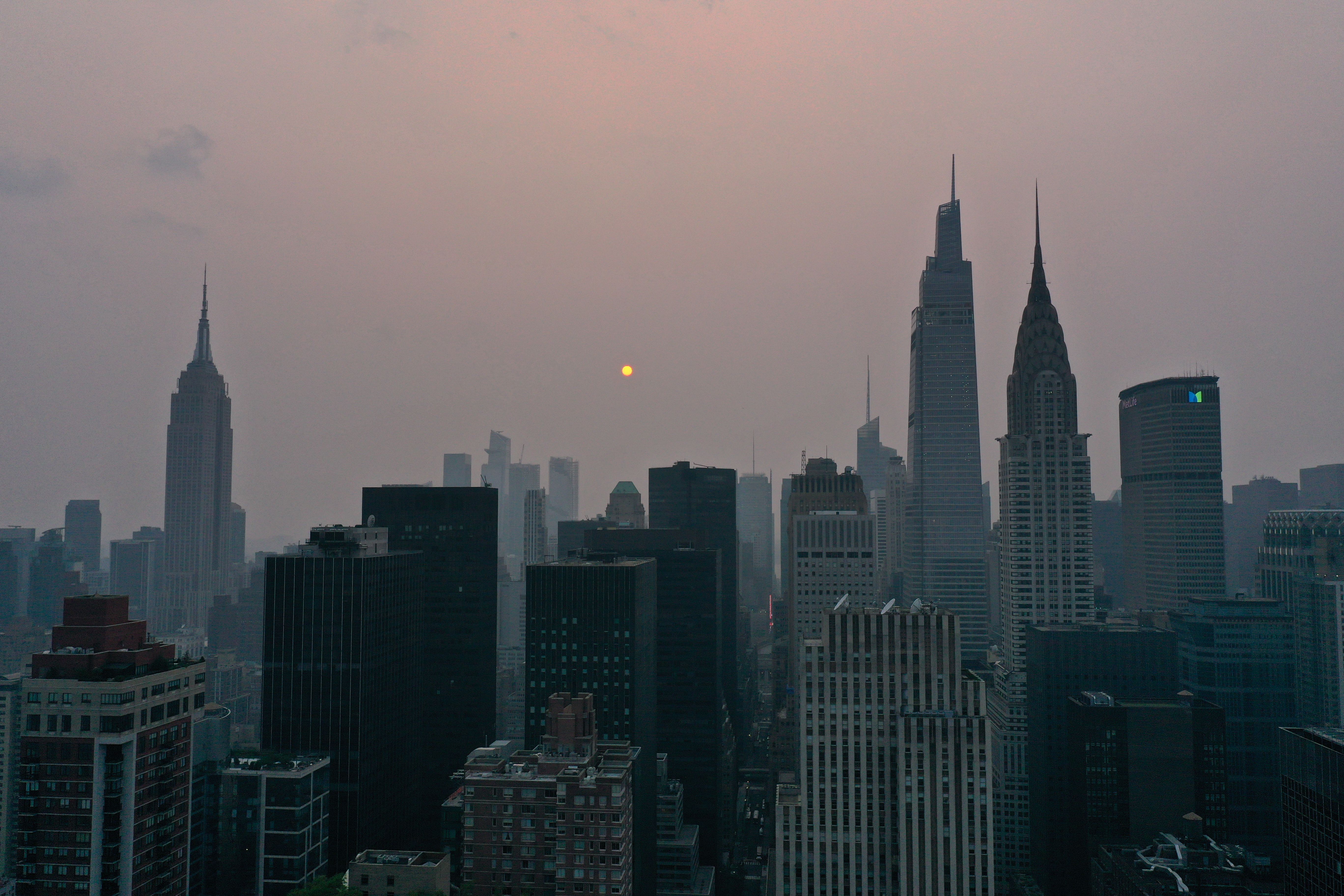 Sunlight interacting with the wildfire smoke, causing the sun to appear with a reddish-orange tint in New York City on July 20.