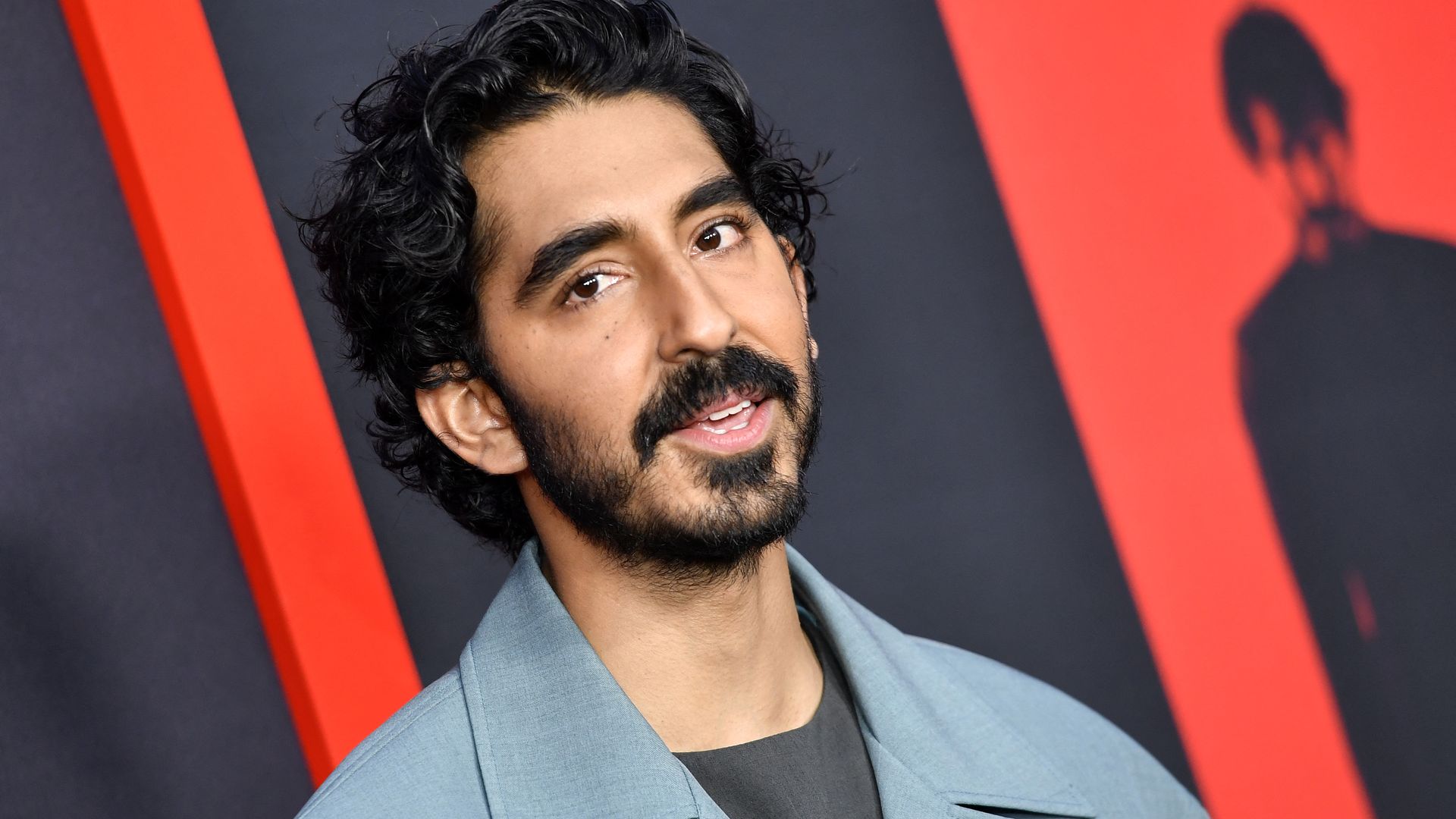 photo of a man standing in front of a movie poster
