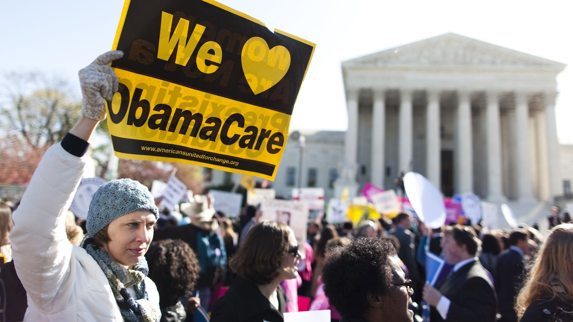 A protestor waving a pro-ACA sign outside the Supreme Court