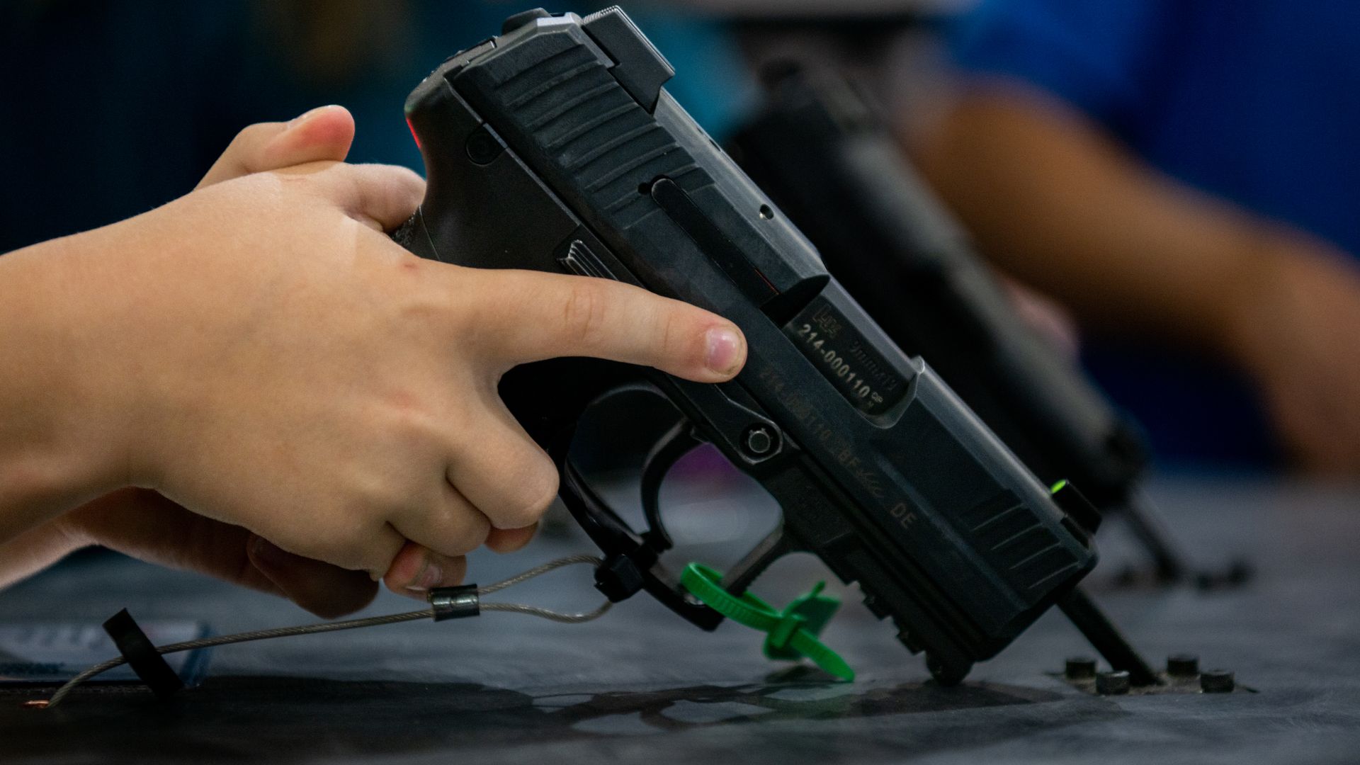 A seven year old picking up a handgun on display at a convention center in Houston in 2022.