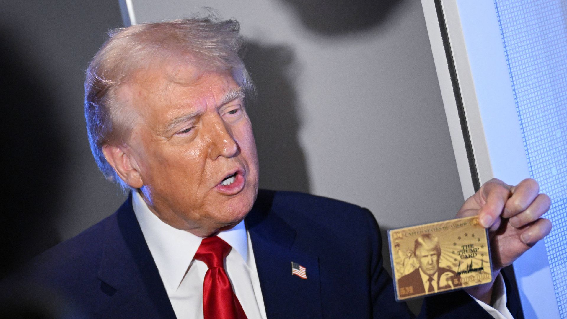 President Donald Trump holds the $5 million dollar Gold Card as he speaks to reporters while in flight on board Air Force One, en route to Miami, Florida on April 3, 2025. Trump is travelling to the Trump National Doral Golf Club before going to his Mar-a-Lago Resort. 