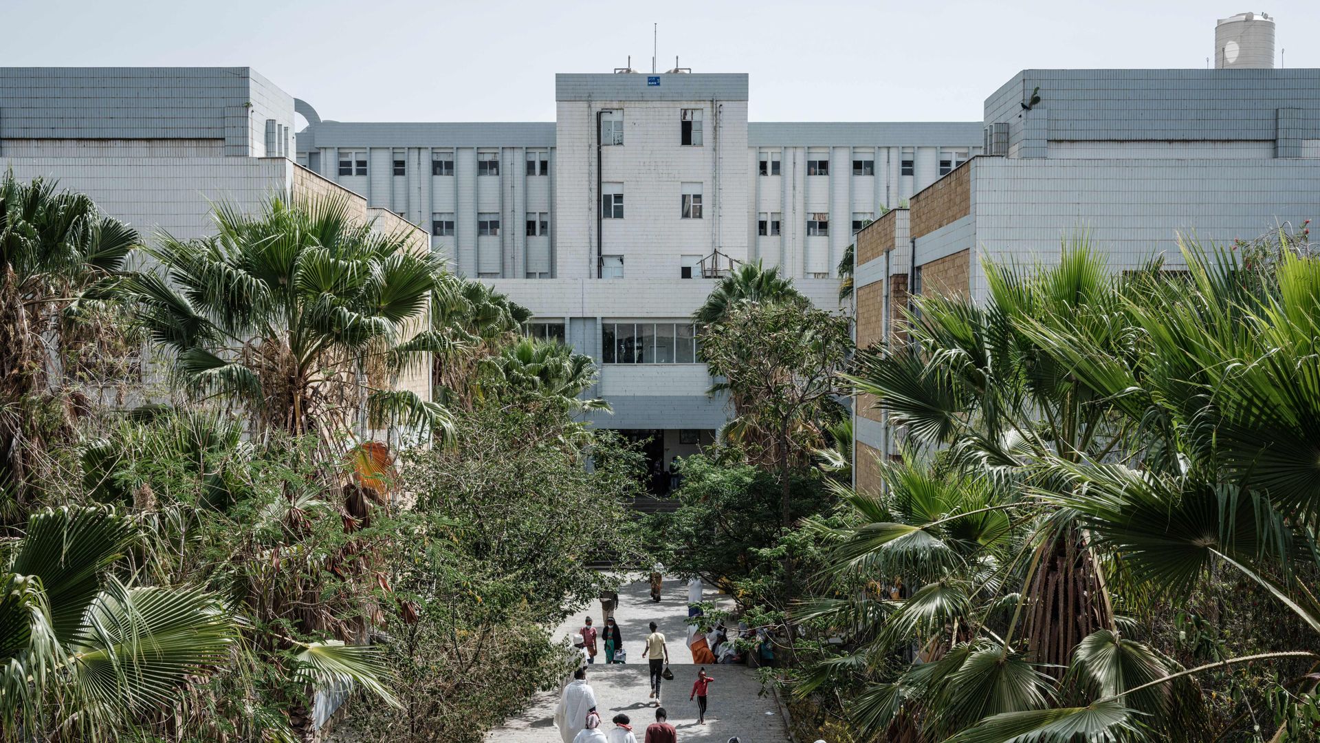 People walk towards the Ayder referral hospital in Mekele, on June 24, 2021, two days after a deadly airstrike on a market in Ethiopia.