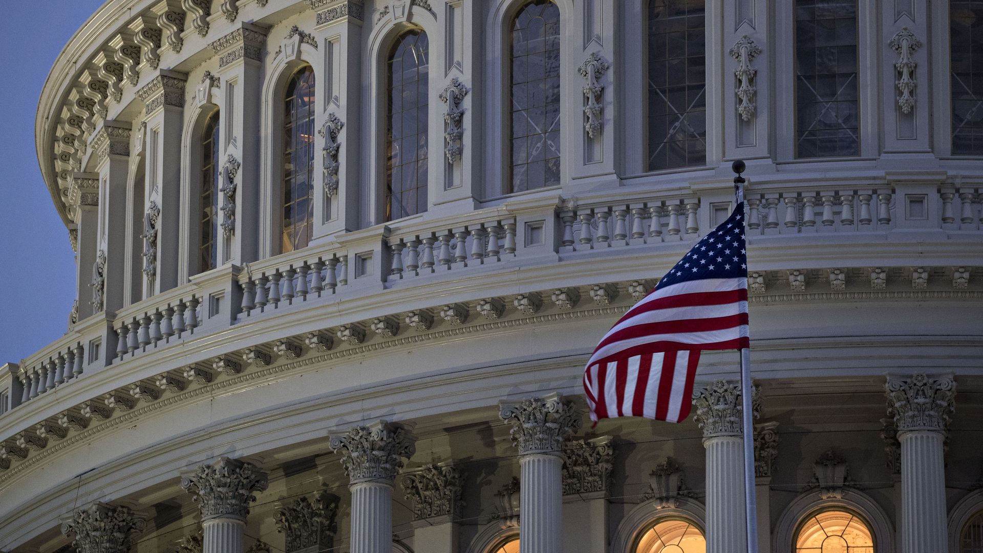 The American flag flies outside the U.S. Capitol before sunrise