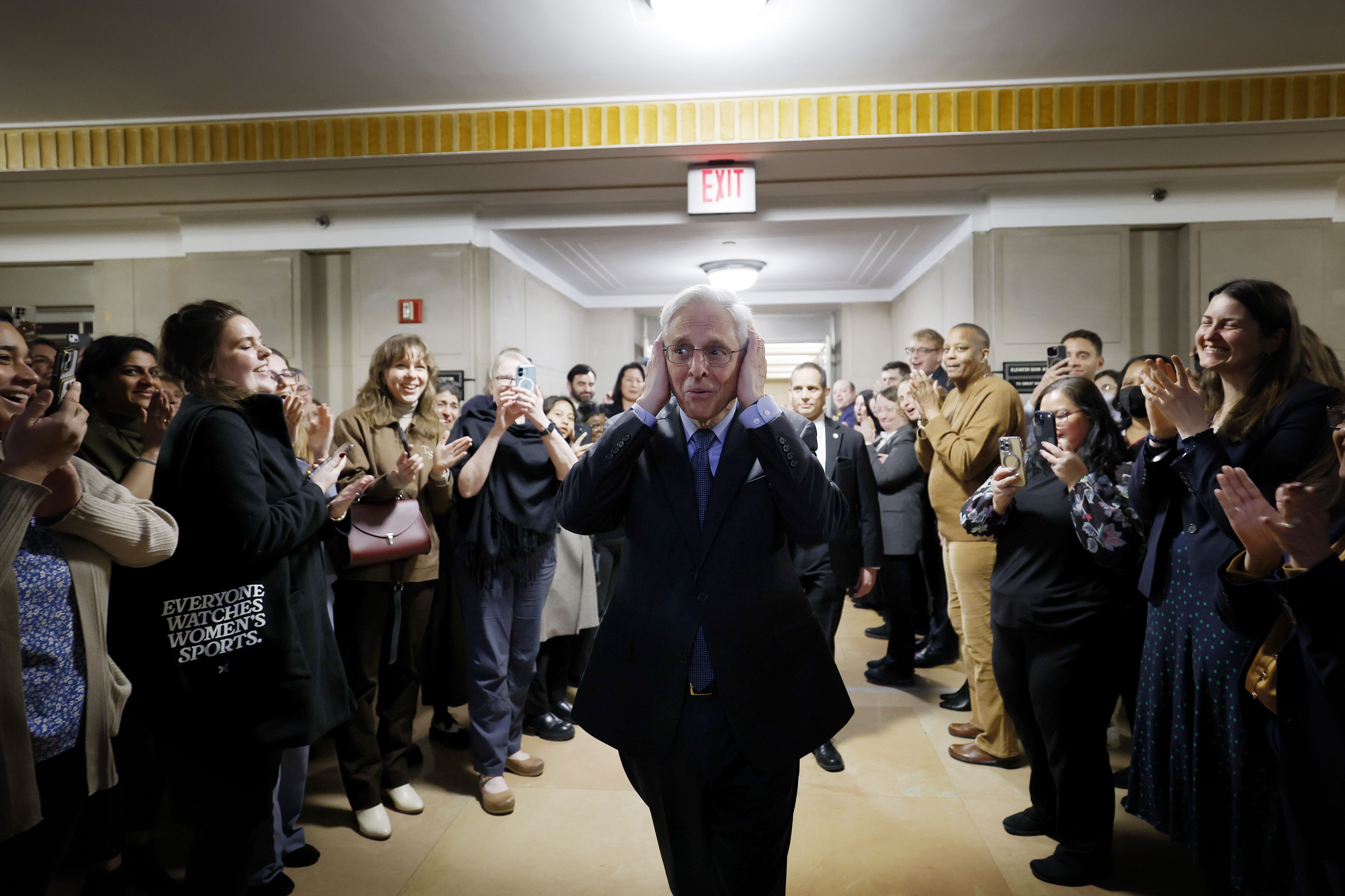: U.S. Attorney General Merrick Garland covers his ears in reaction to employees of the U.S. Department of Justice sending him off as he departs from the U.S. Justice Department Building on January 17, 2025 in Washington, DC. The ceremony was to honor Garland's last day as Attorney General. (Photo b